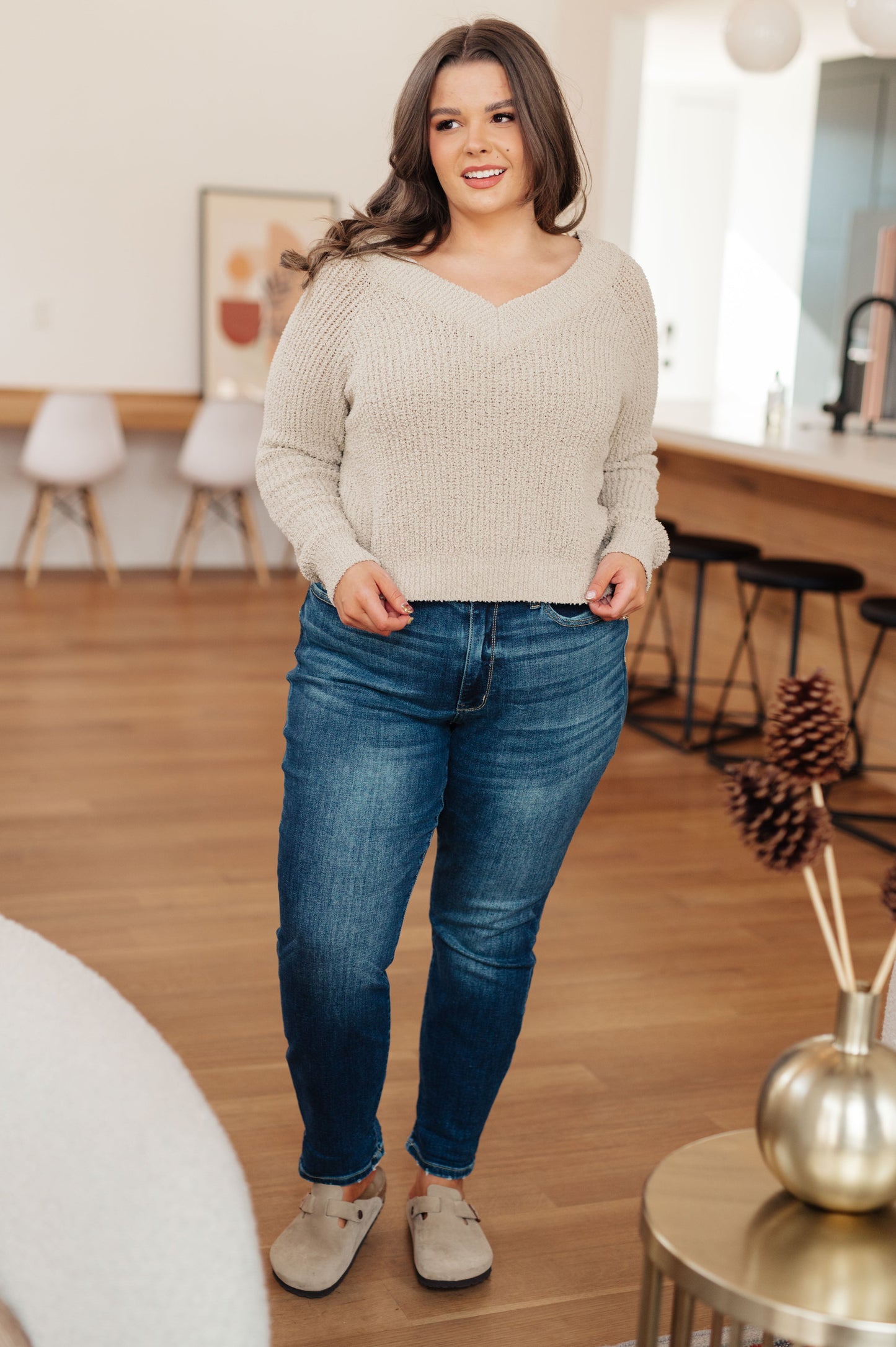 Plus size model pairing Suki V-Neck Sweater with jeans for a cozy look.