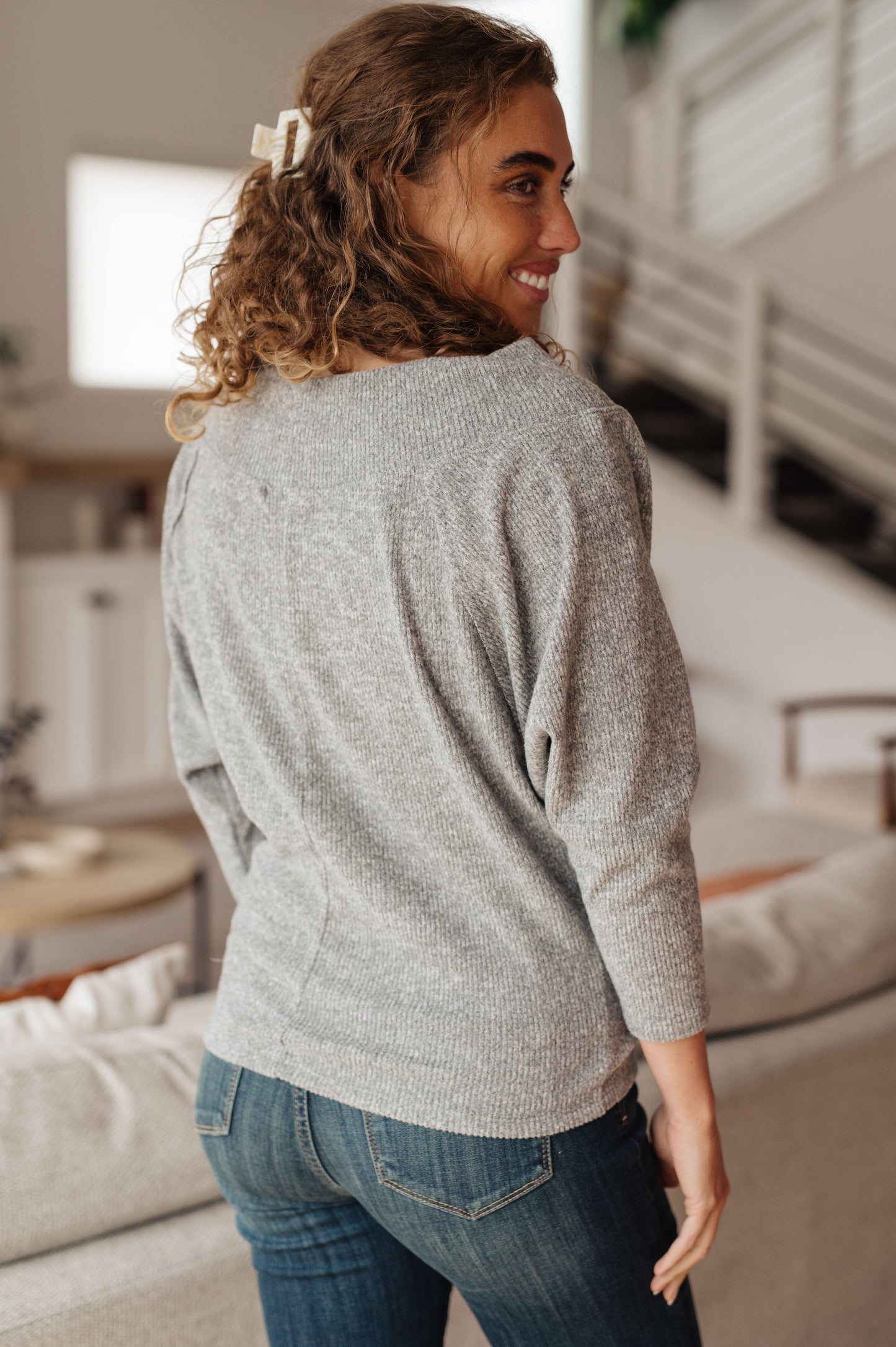 Light gray textured knit top features a boat neckline, and dolman sleeves.