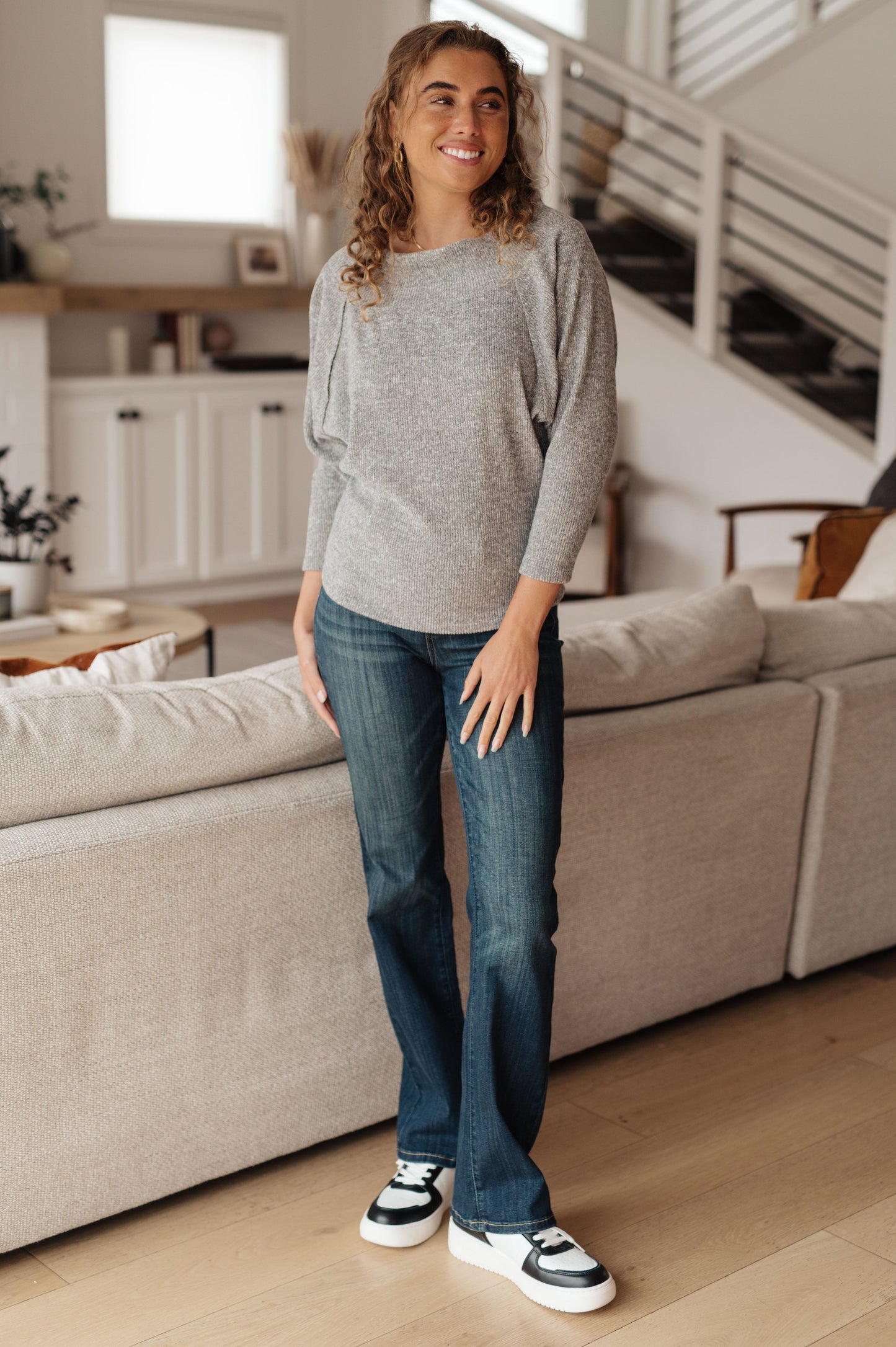 Light gray textured knit top features a boat neckline, and dolman sleeves.