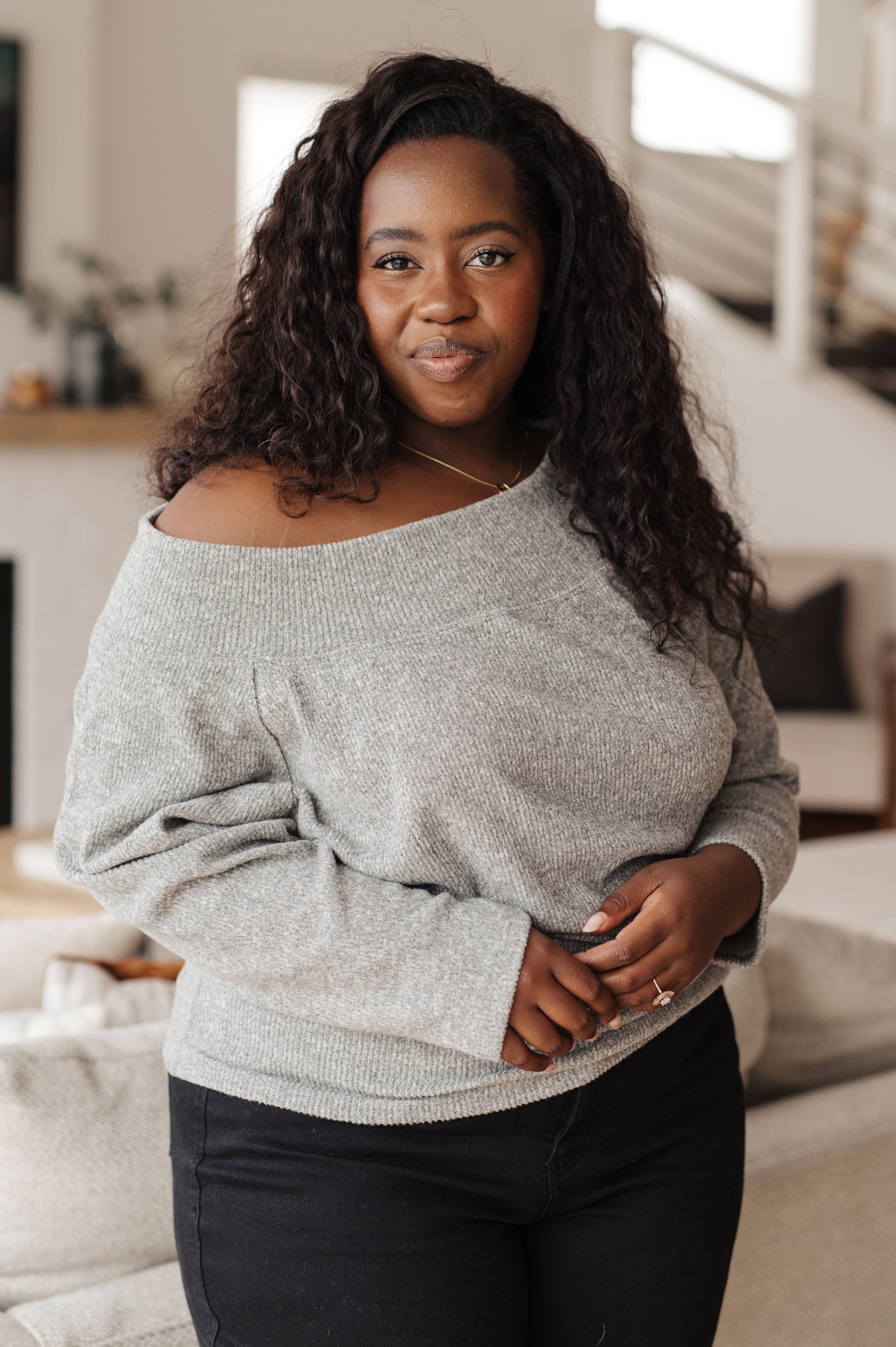 Light gray textured knit top features a boat neckline, and dolman sleeves.