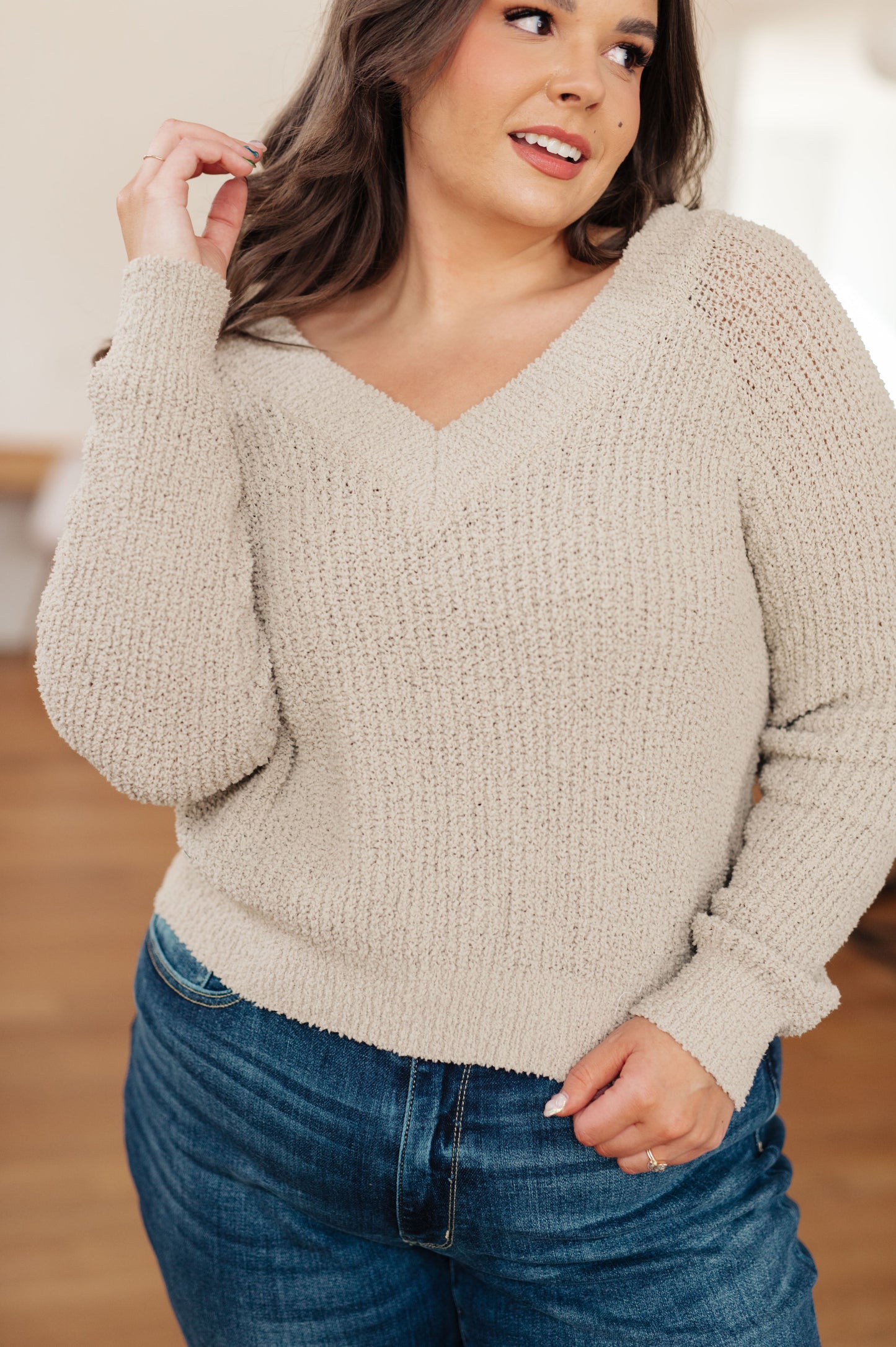 Plus size model wearing Suki V-Neck Sweater in beige with dual V-neckline.