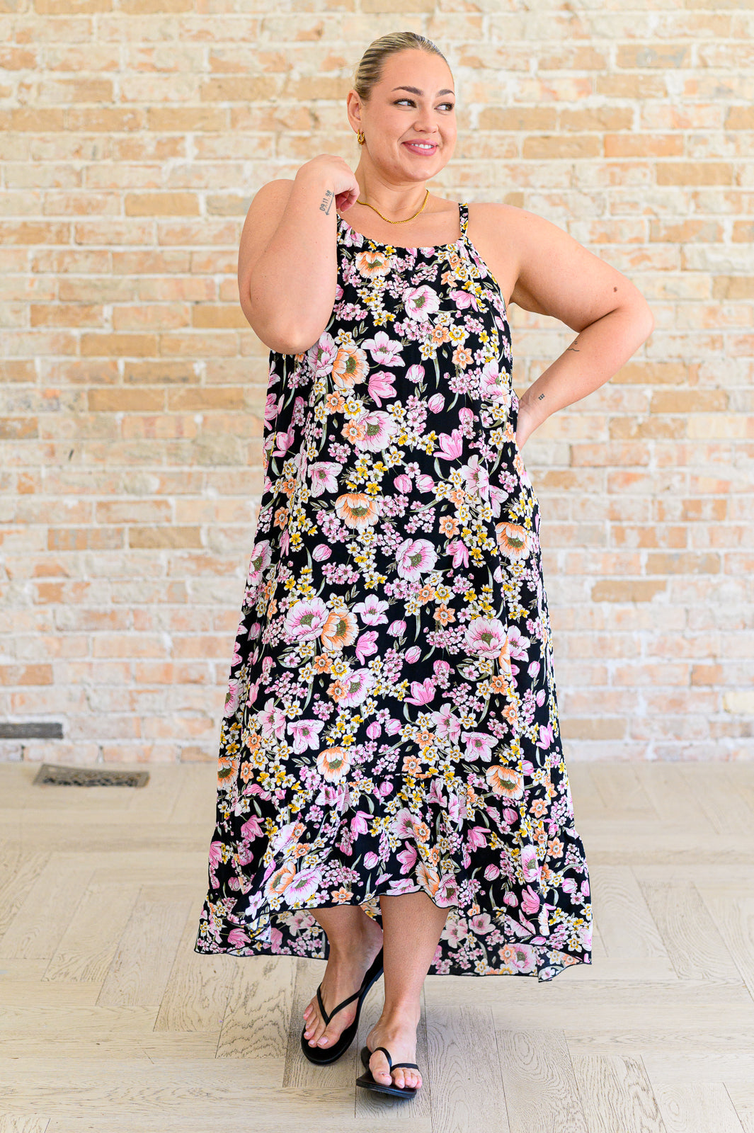 Plus size model in Samantha Halter Dress, black floral print with halter neckline and flowy ruffled hem.