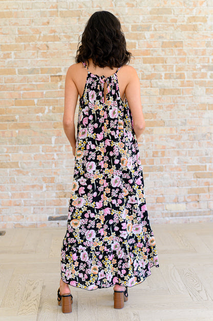 Back view of Samantha Halter Dress in black floral highlighting halter tie and flowy ruffled hem.