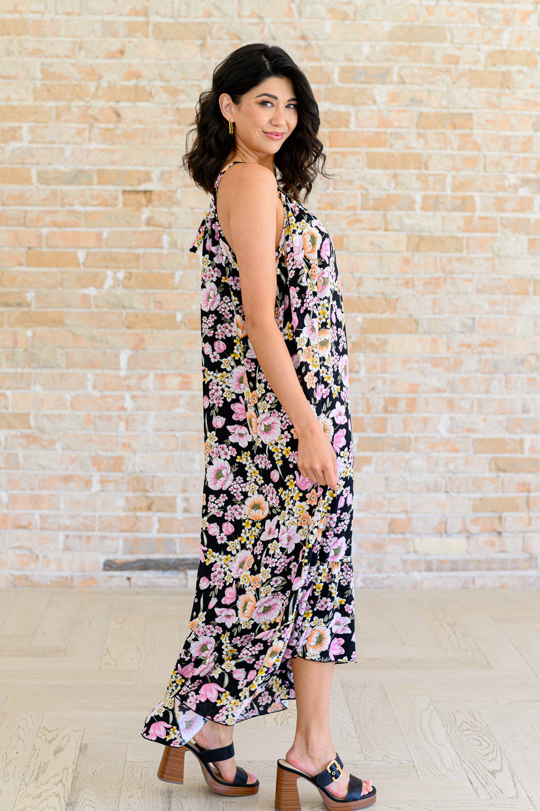 Side view of Sunny Halter Floral Dress highlighting flowy woven fabric and ruffle hem.