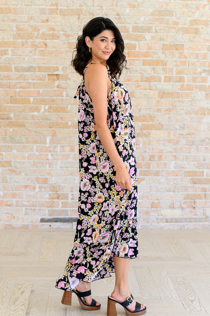 Side view of Sunny Halter Floral Dress highlighting flowy woven fabric and ruffle hem.