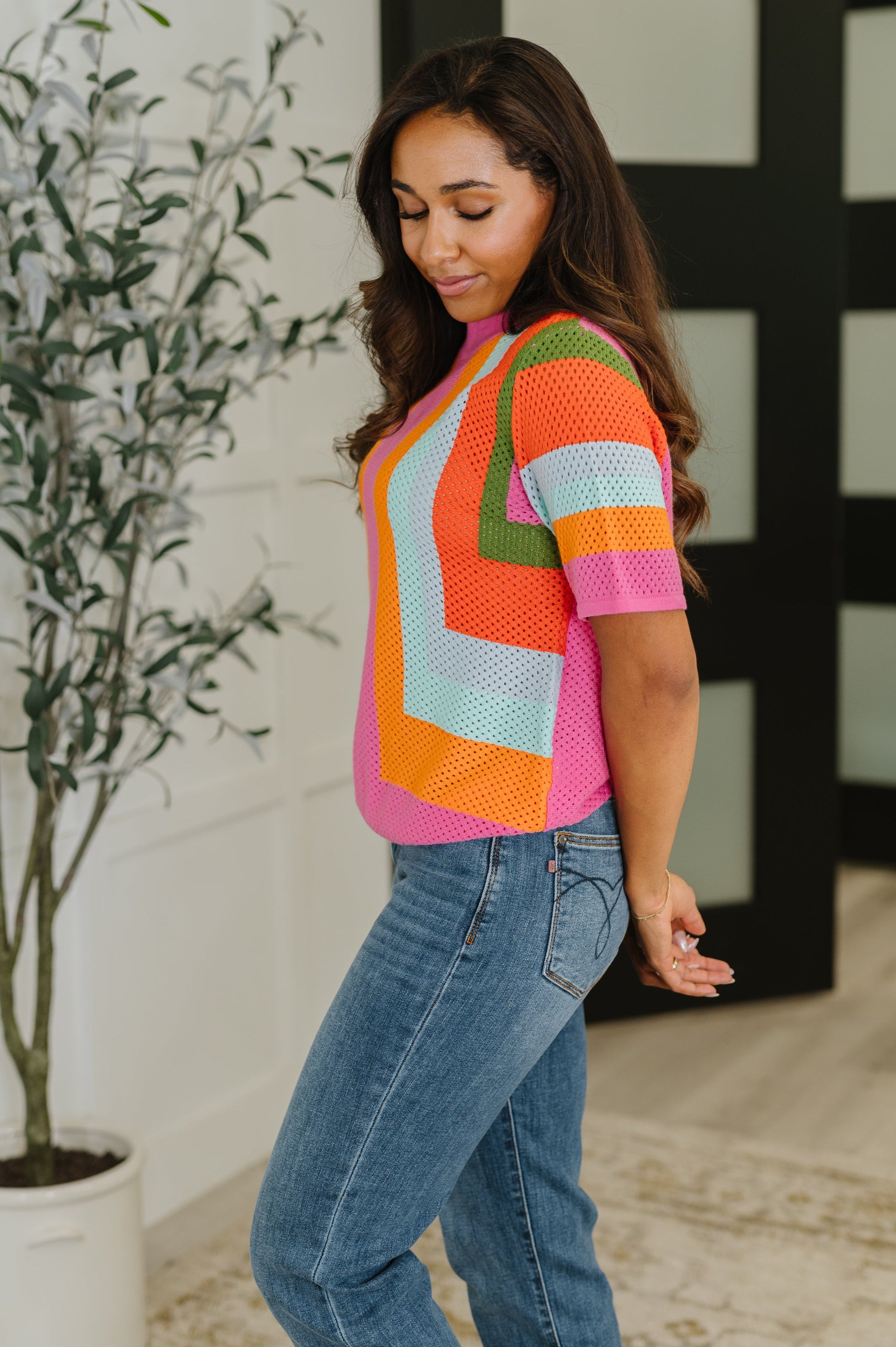 Side profile of Blyss Knit Top highlighting colorful stripes and relaxed fit.