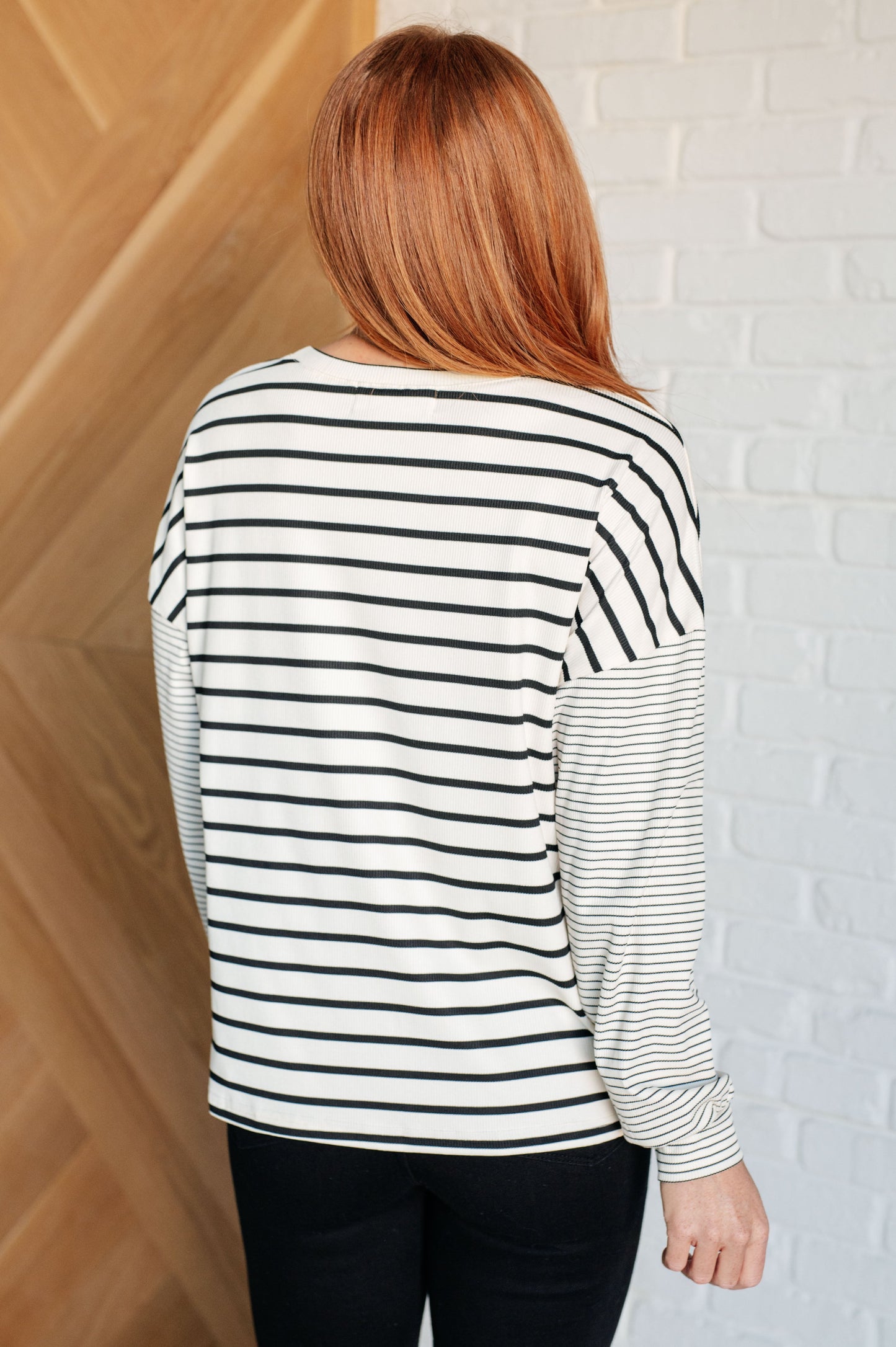 Ivory and black striped women's top with a round neckline, long drop shoulder sleeves, and banded sleeve cuffs, made from cozy micro ribbed knit fabric.