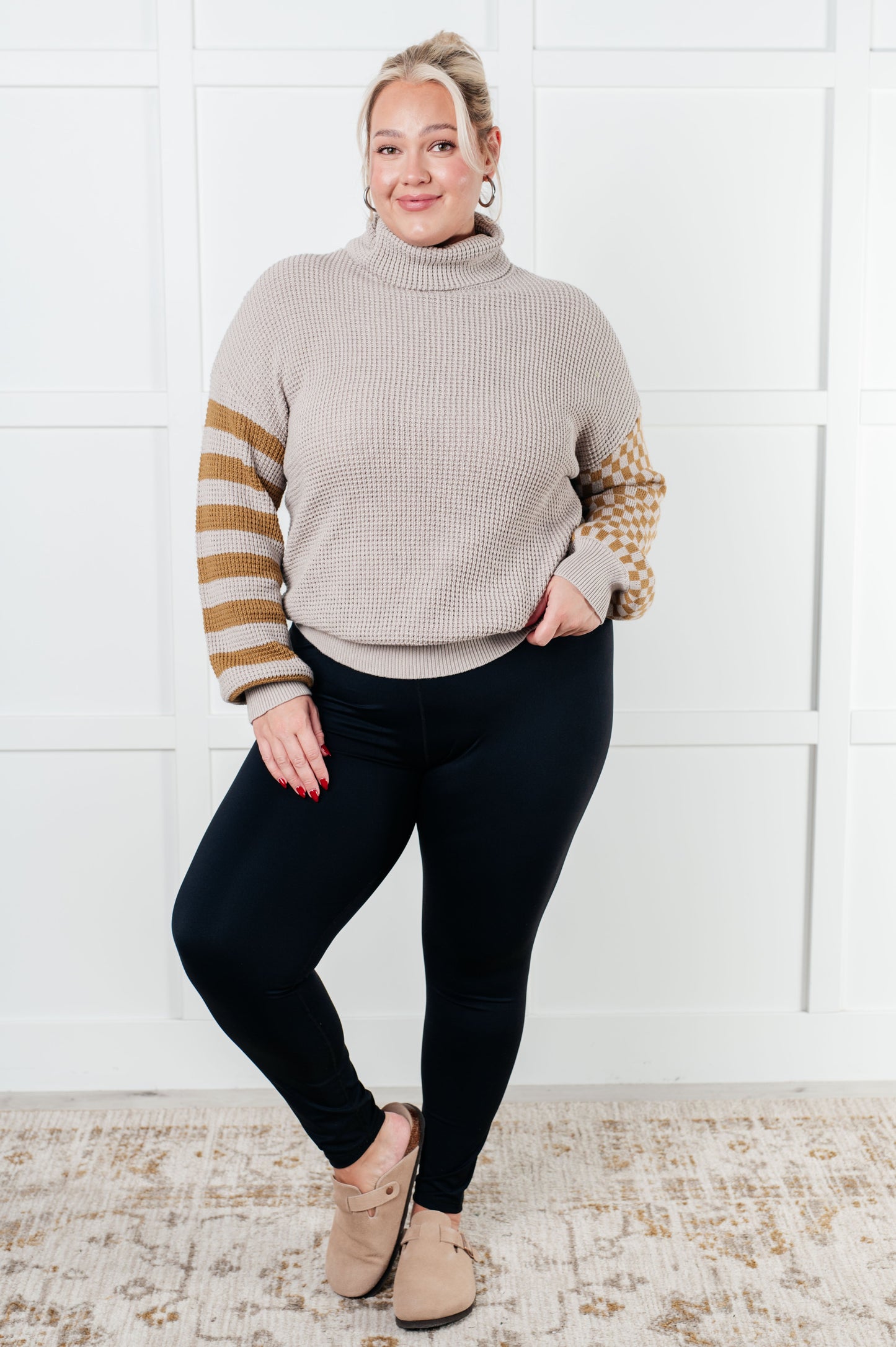 Suzi Patchwork Waffle Knit Sweater with a soft waffle knit texture, turtle neckline, drop shoulder design, and banded ribbed details, featuring check and striped patterns.