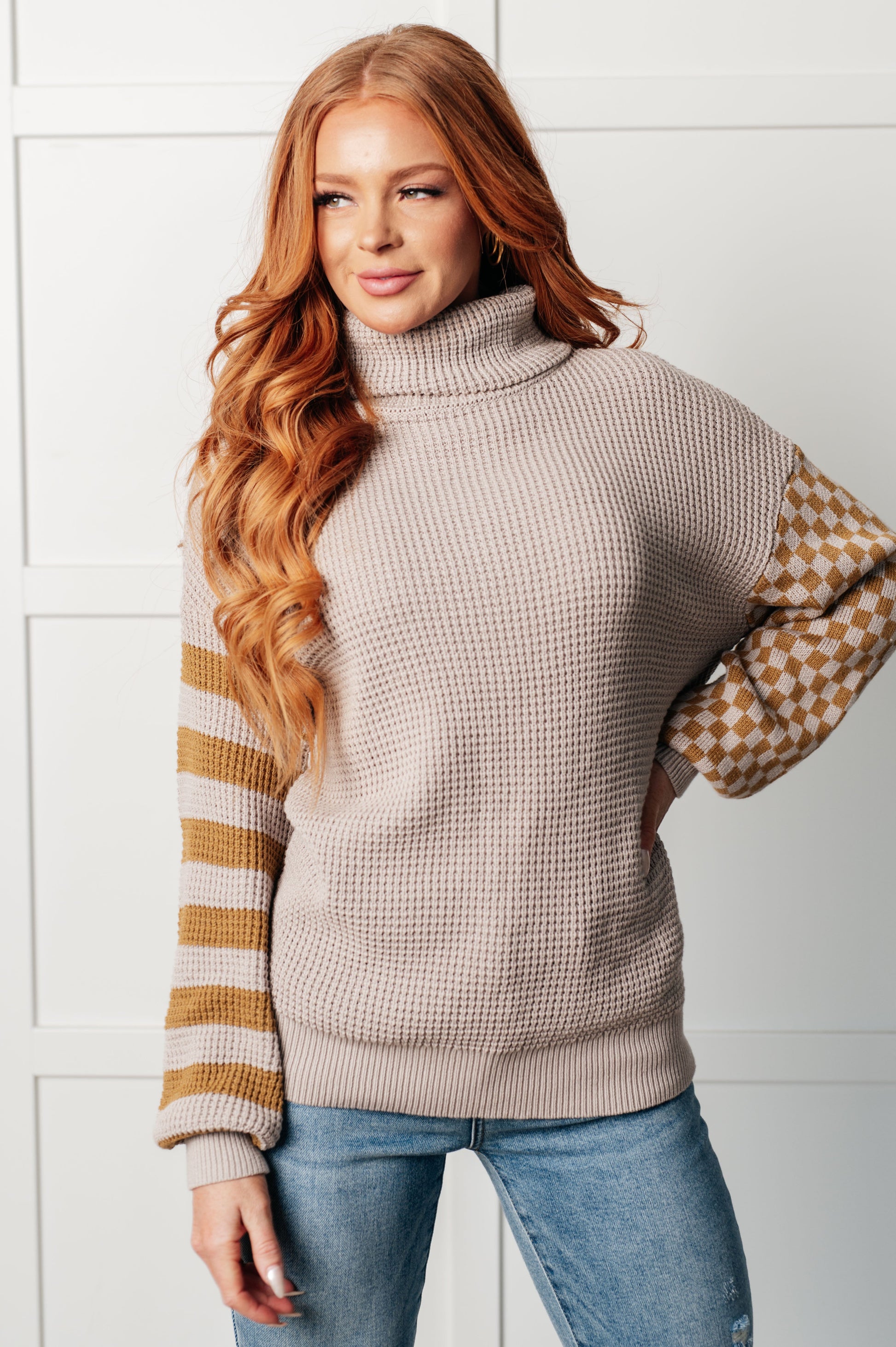 Suzi Patchwork Waffle Knit Sweater with a soft waffle knit texture, turtle neckline, drop shoulder design, and banded ribbed details, featuring check and striped patterns.