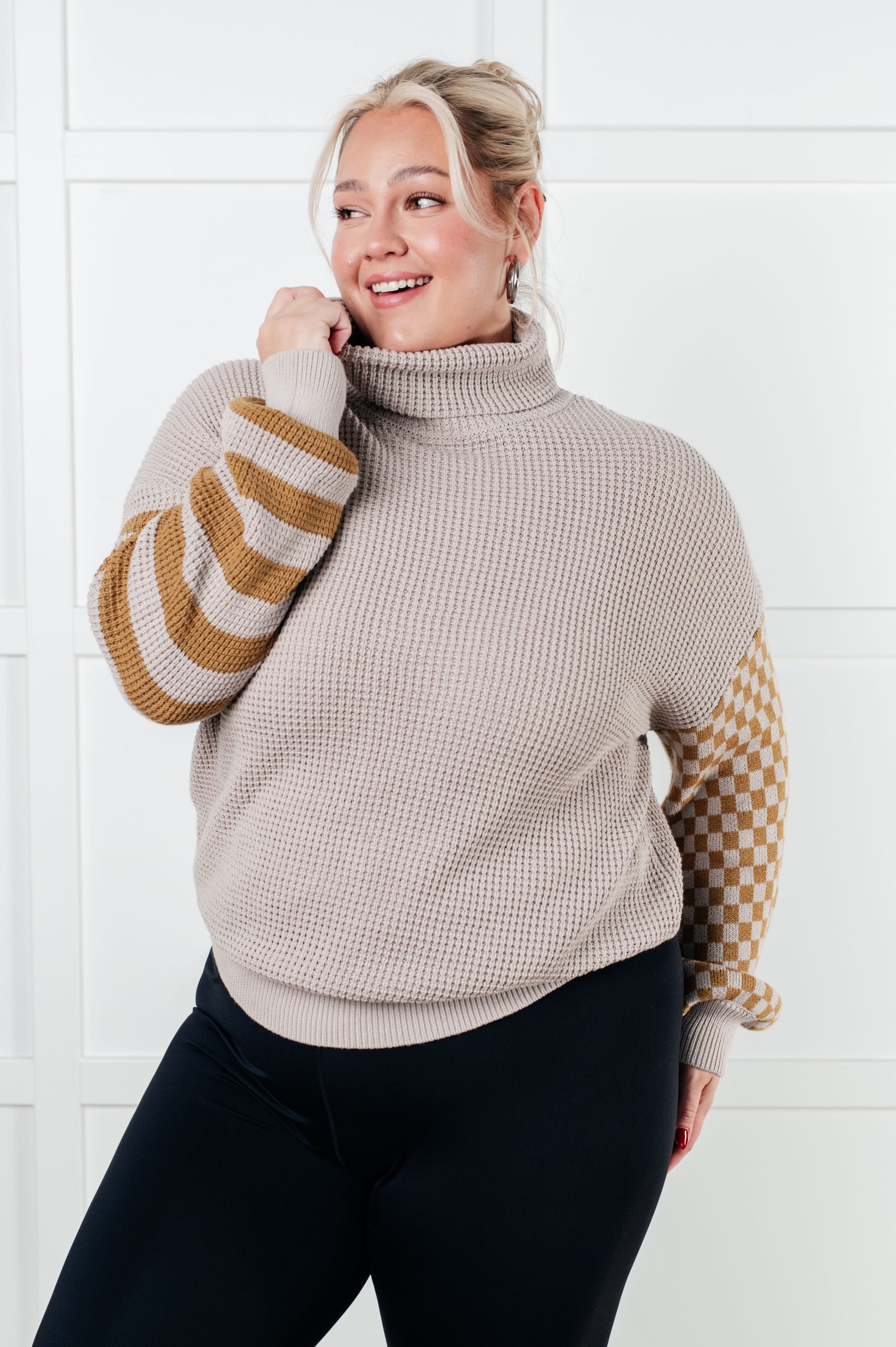 Suzi Patchwork Waffle Knit Sweater with a soft waffle knit texture, turtle neckline, drop shoulder design, and banded ribbed details, featuring check and striped patterns.