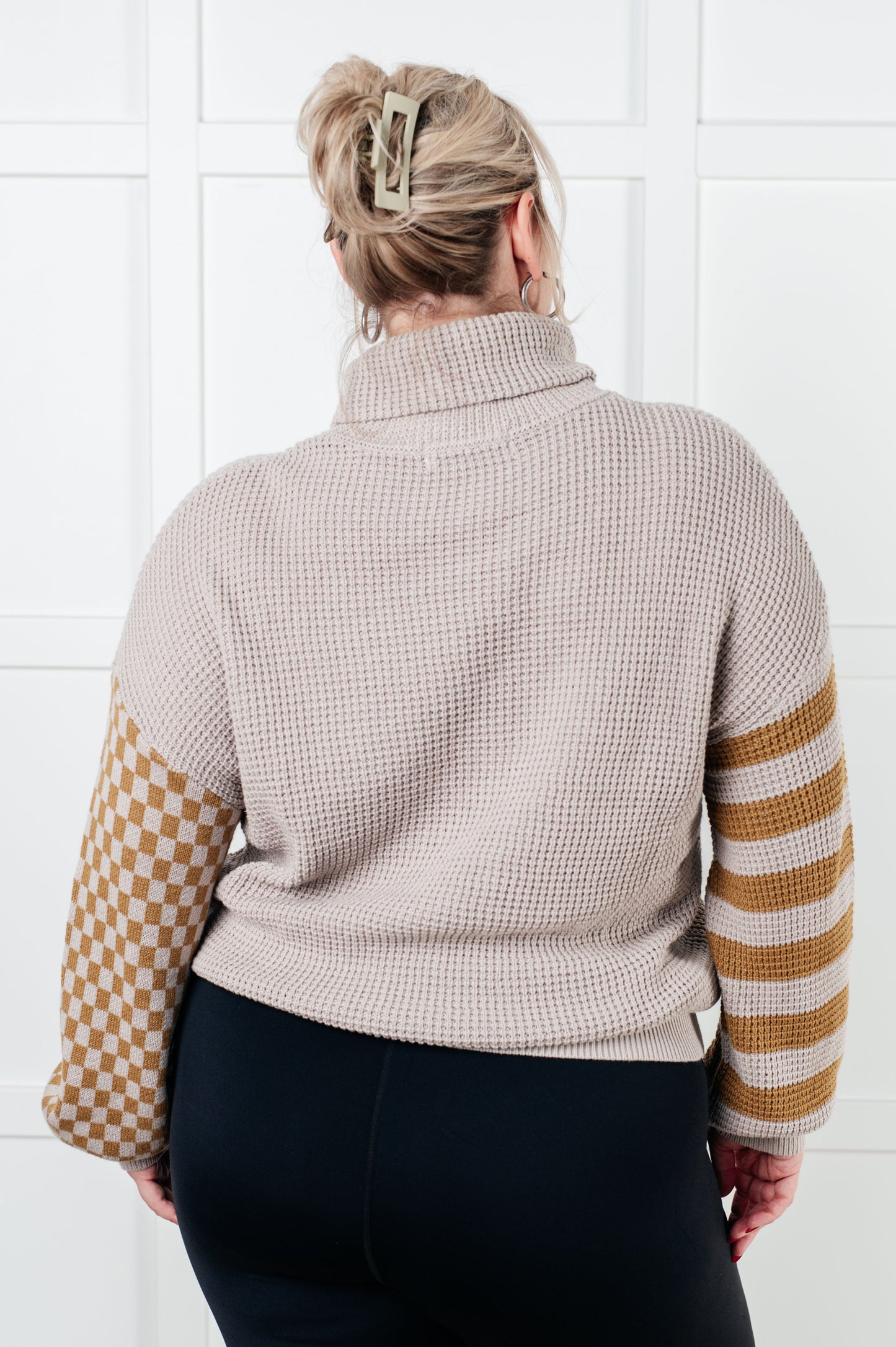 Suzi Patchwork Waffle Knit Sweater with a soft waffle knit texture, turtle neckline, drop shoulder design, and banded ribbed details, featuring check and striped patterns.