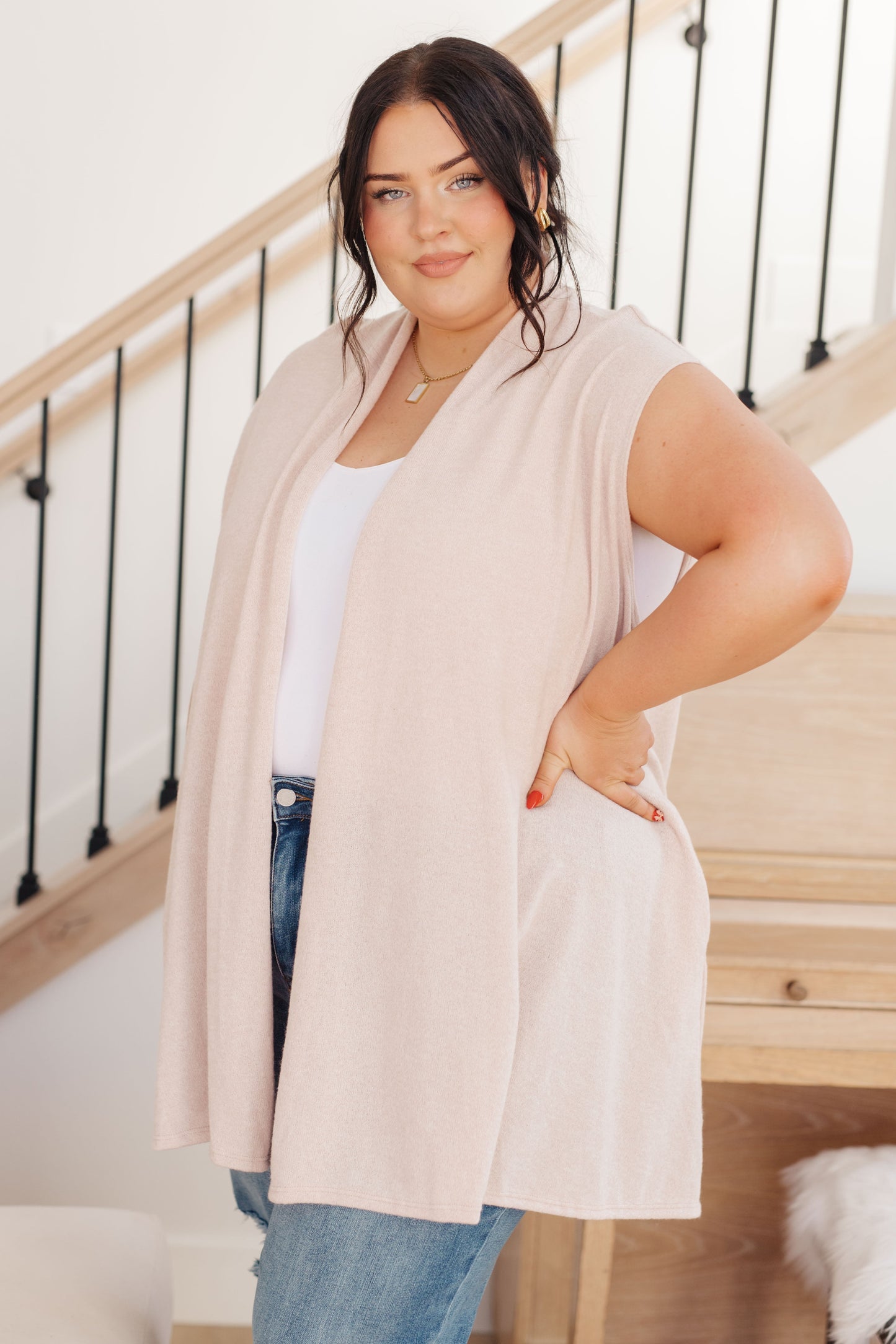 Women's light beige sleeveless cardigan made from lightweight sweater knit fabric, featuring a shawl collar, open front, and pockets.