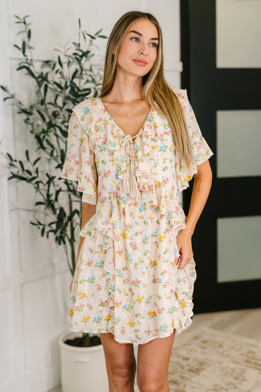 Front-facing view of model wearing the Addison Boho Floral Dress, showcasing flutter sleeves and ruffle details.