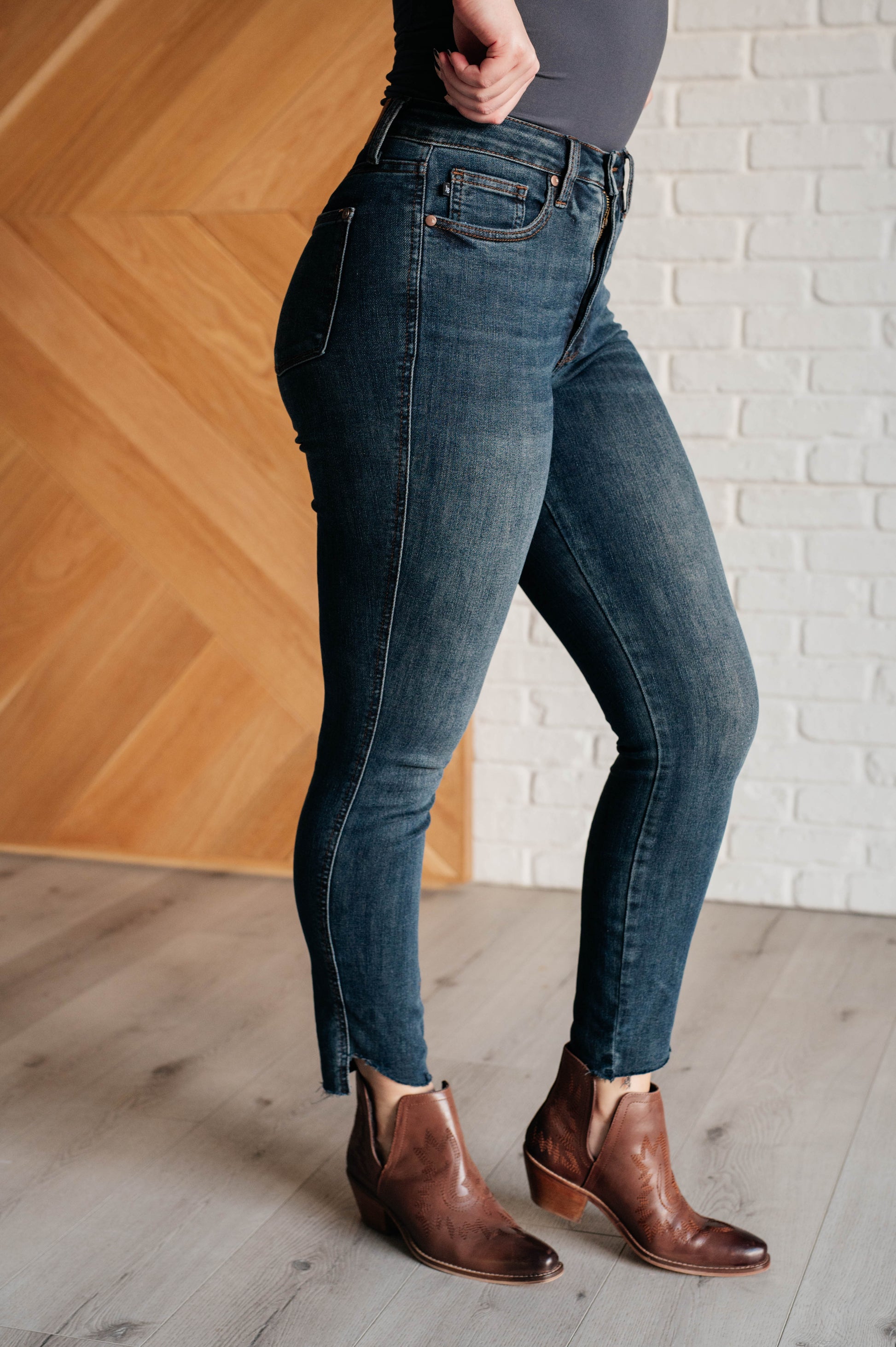 Tessa High Rise Control Top Step Hem Skinny Jeans with a flattering high rise, slimming tummy control, and stylish stepped raw hem in dark wash, perfect for any occasion.