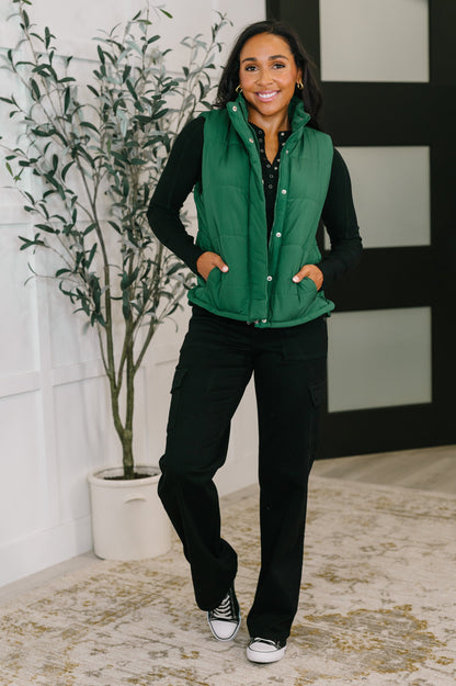 Model wearing Izabella Puffer Vest in hunter green styled with black top and pants.