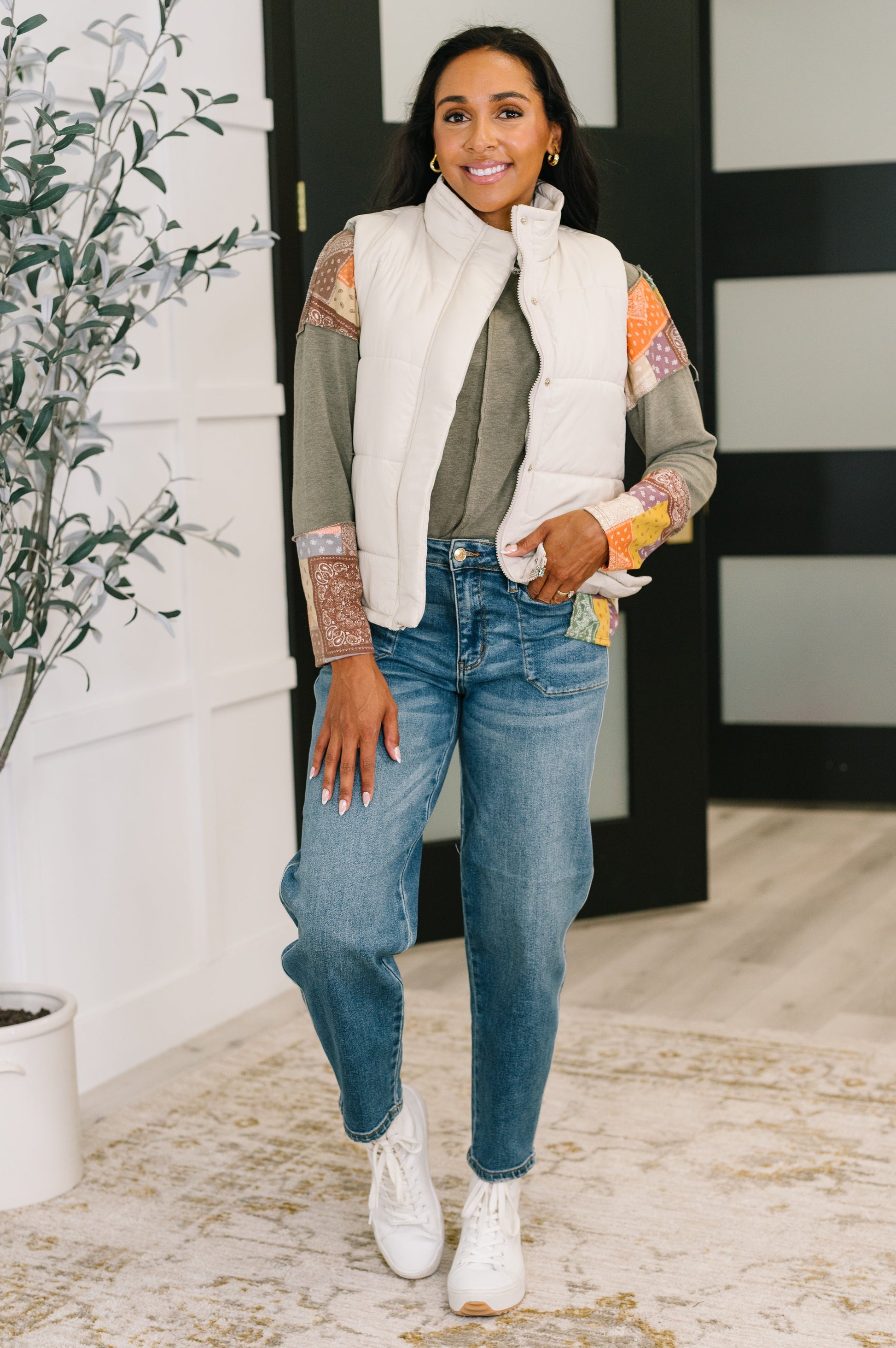 Model wearing Izabella Puffer Vest in sand beige with jeans and neutral long sleeve top.