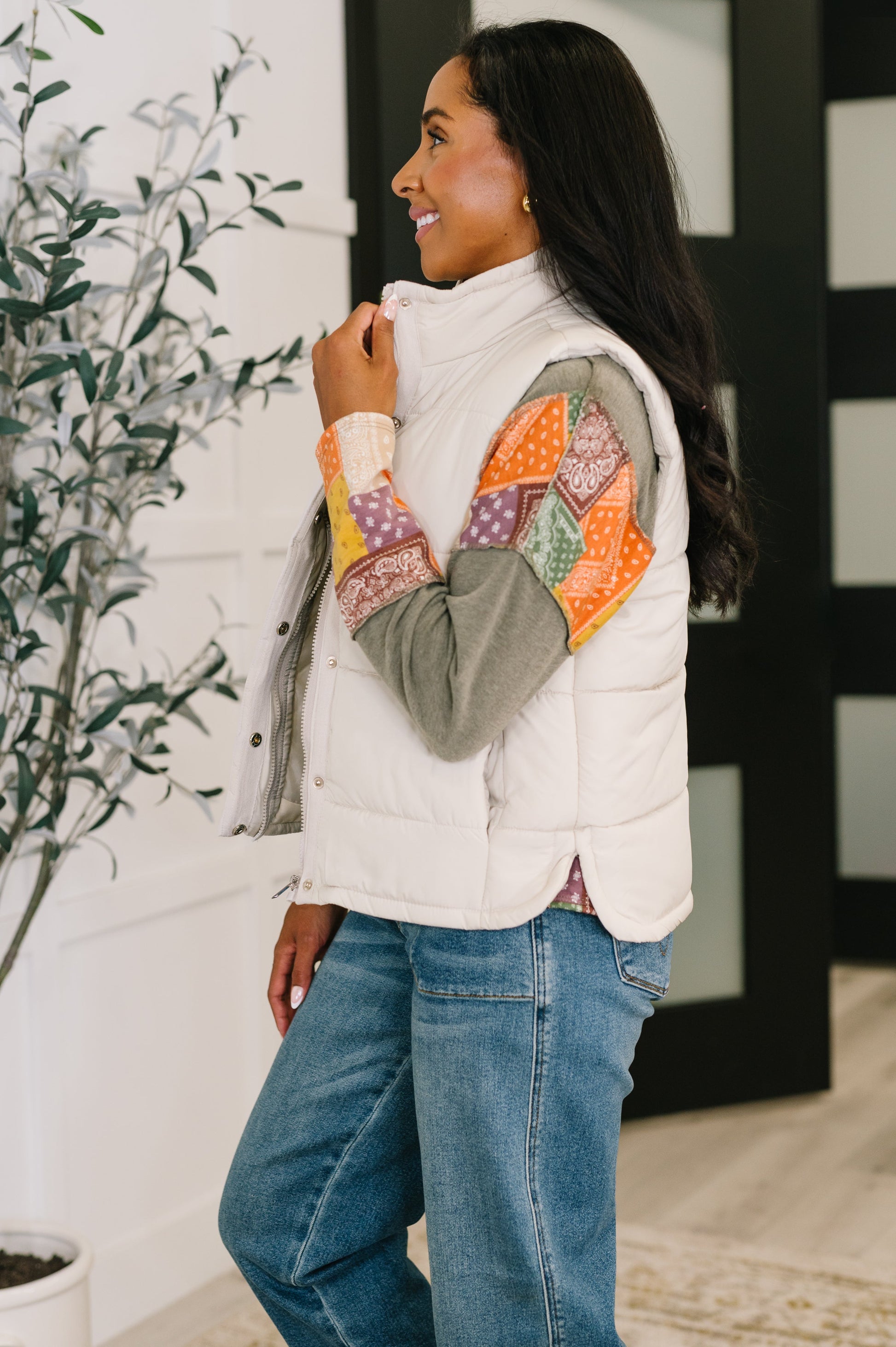 Side angle of Izabella Puffer Vest in sand beige highlighting side slits and pockets.