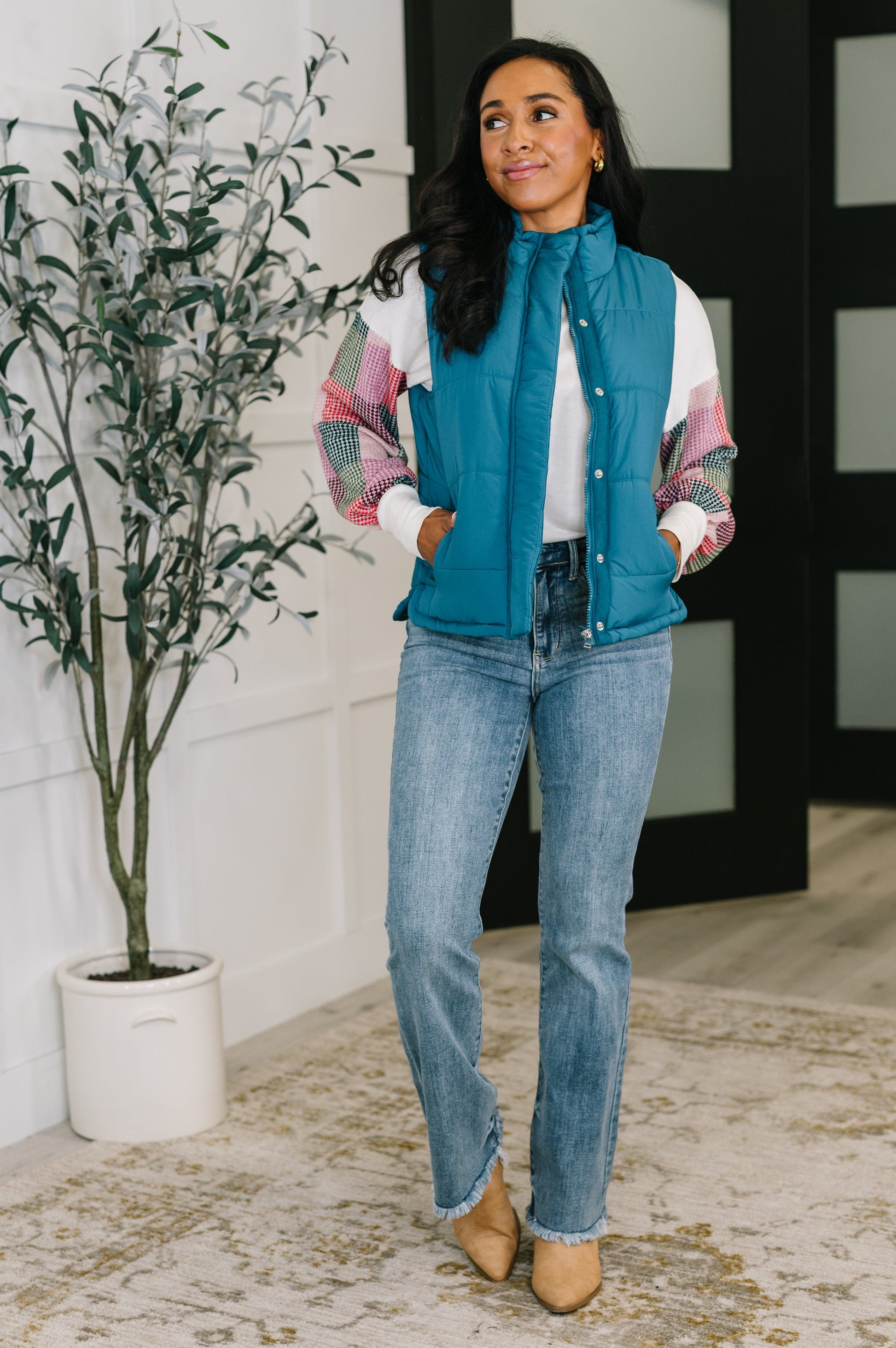 Model wearing Izabella Puffer Vest in teal with jeans and neutral top, full body view.