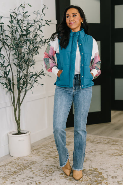 Model wearing Izabella Puffer Vest in teal with jeans and neutral top, full body view.