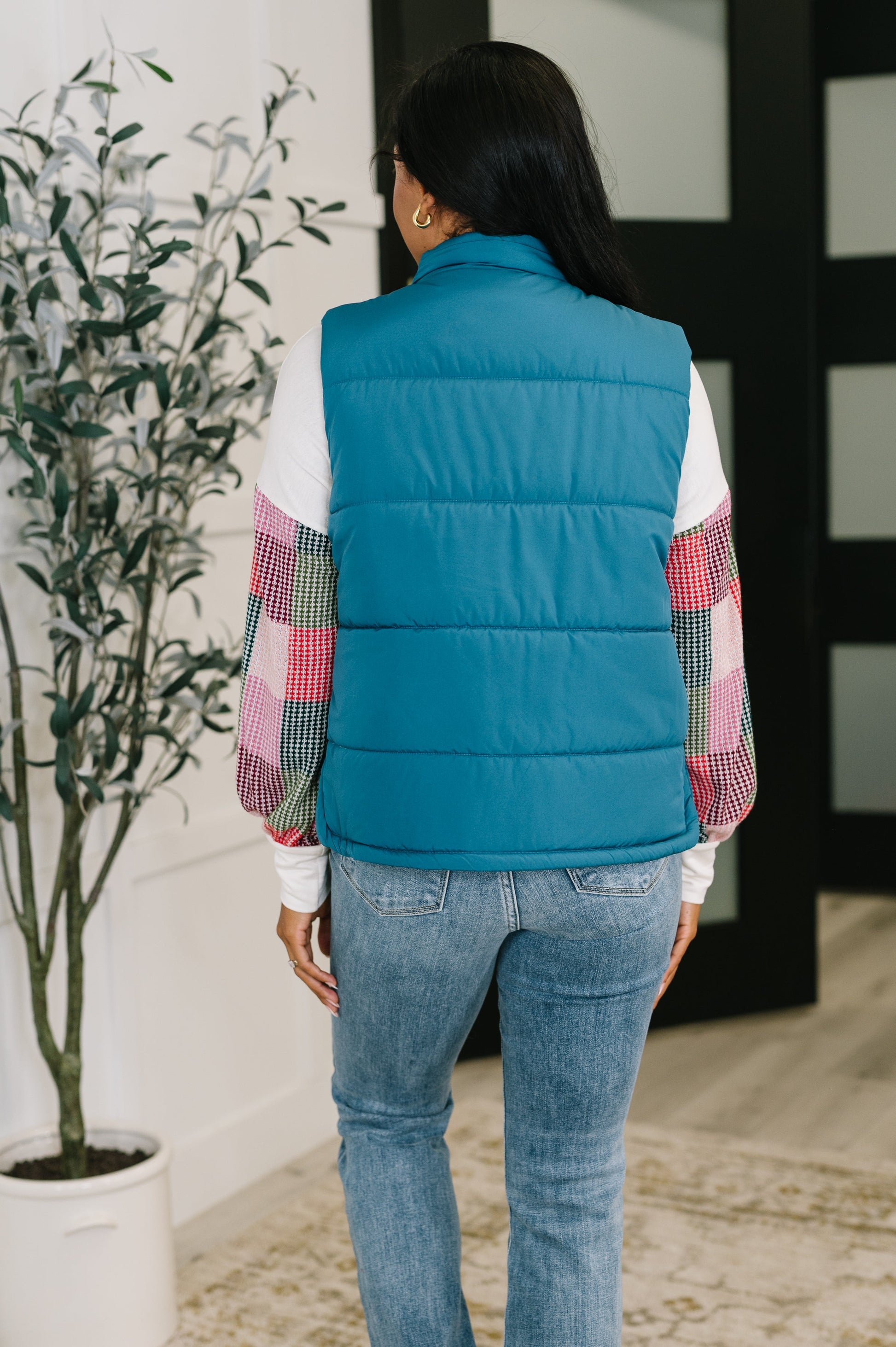 Back of Izabella Puffer Vest in teal showing quilted design and high collar.