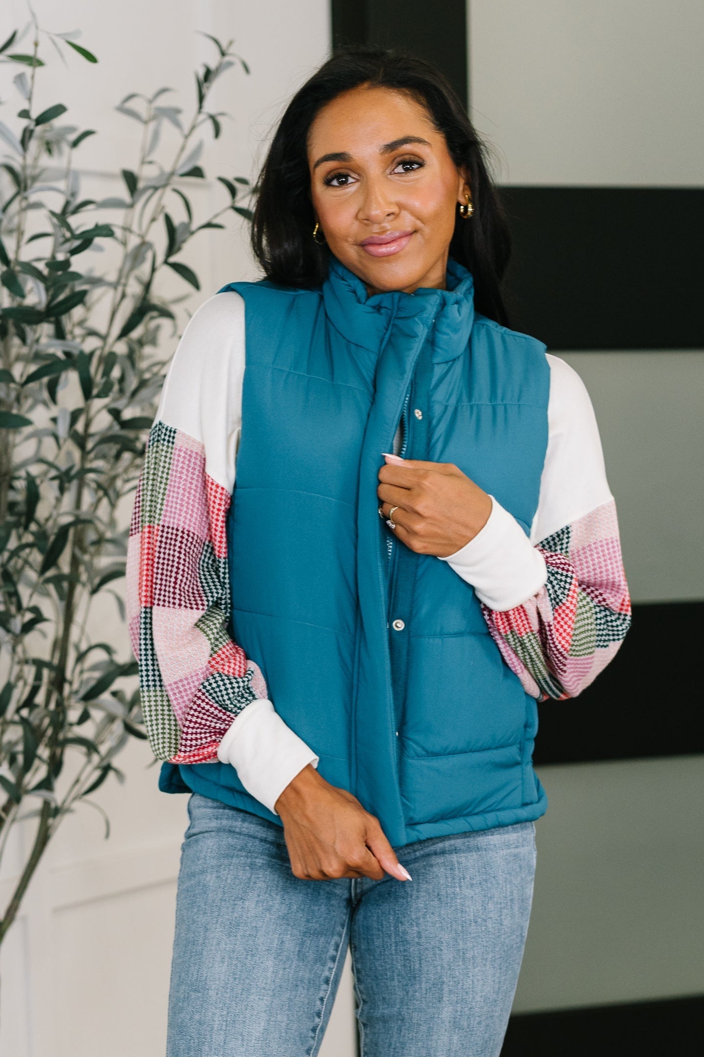 Model wearing Izabella Puffer Vest in teal, front view with high neck and snap closure.