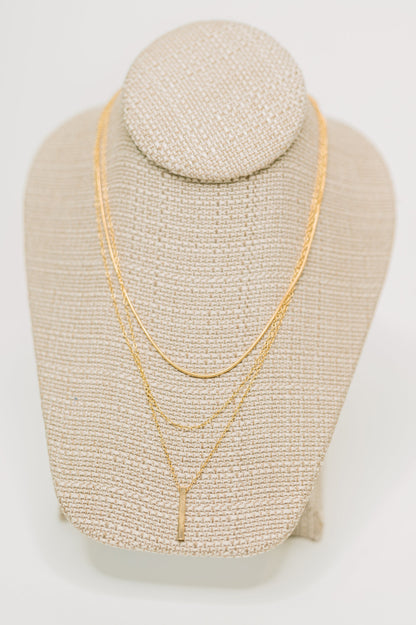 Signature Gold Layered Necklace displayed on jewelry stand