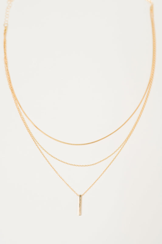 Flat lay of Signature Gold Layered Necklace with bar pendant
