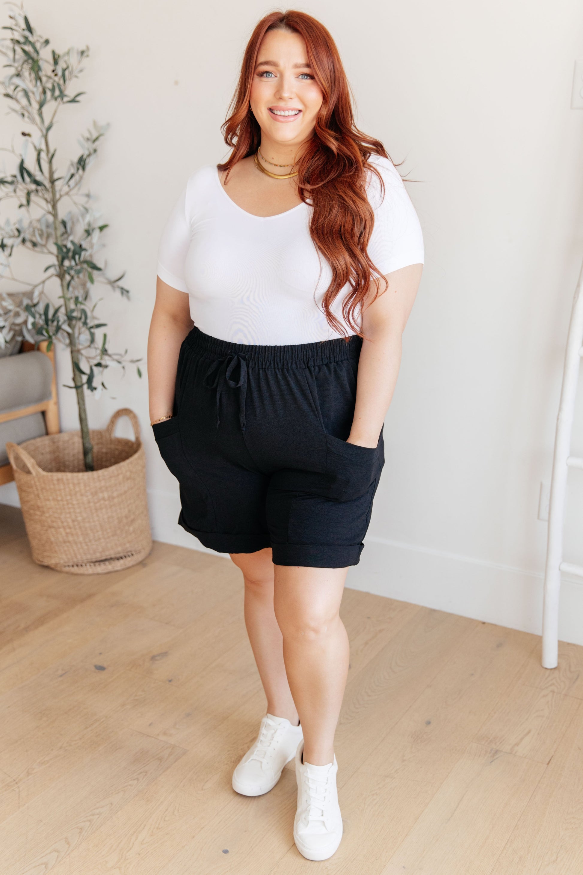 Plus size full body view of Gracelyn Drawstring Shorts in black styled with white tee and sneakers.