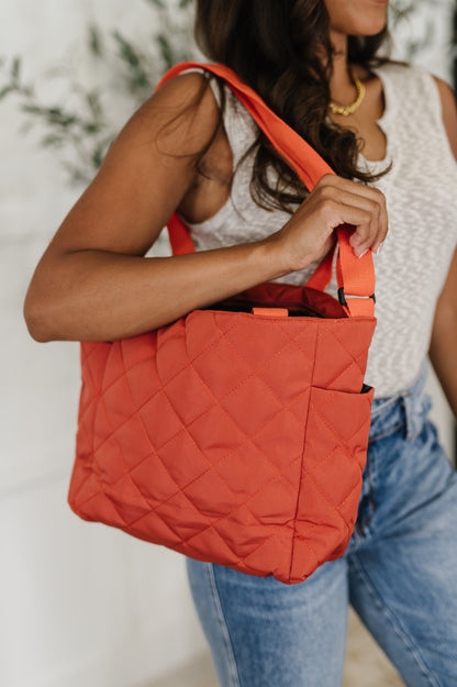 Close-up side view of Tallulah tote bag in tomato red with quilted fabric, soft structure, and side pocket detail