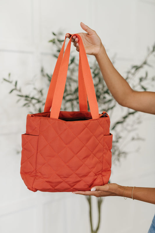 Front view of Tallulah tote bag in tomato red quilted fabric with zipper closure and dual carry straps.