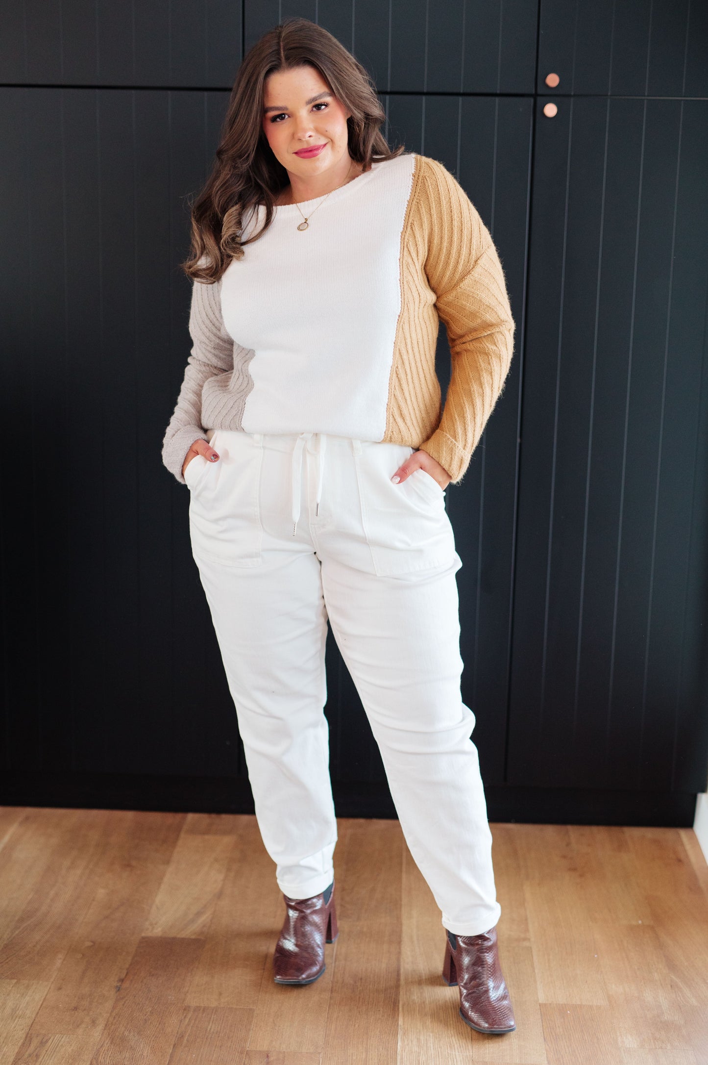 Plus size model wearing Makenna Color Block Sweater with white joggers.