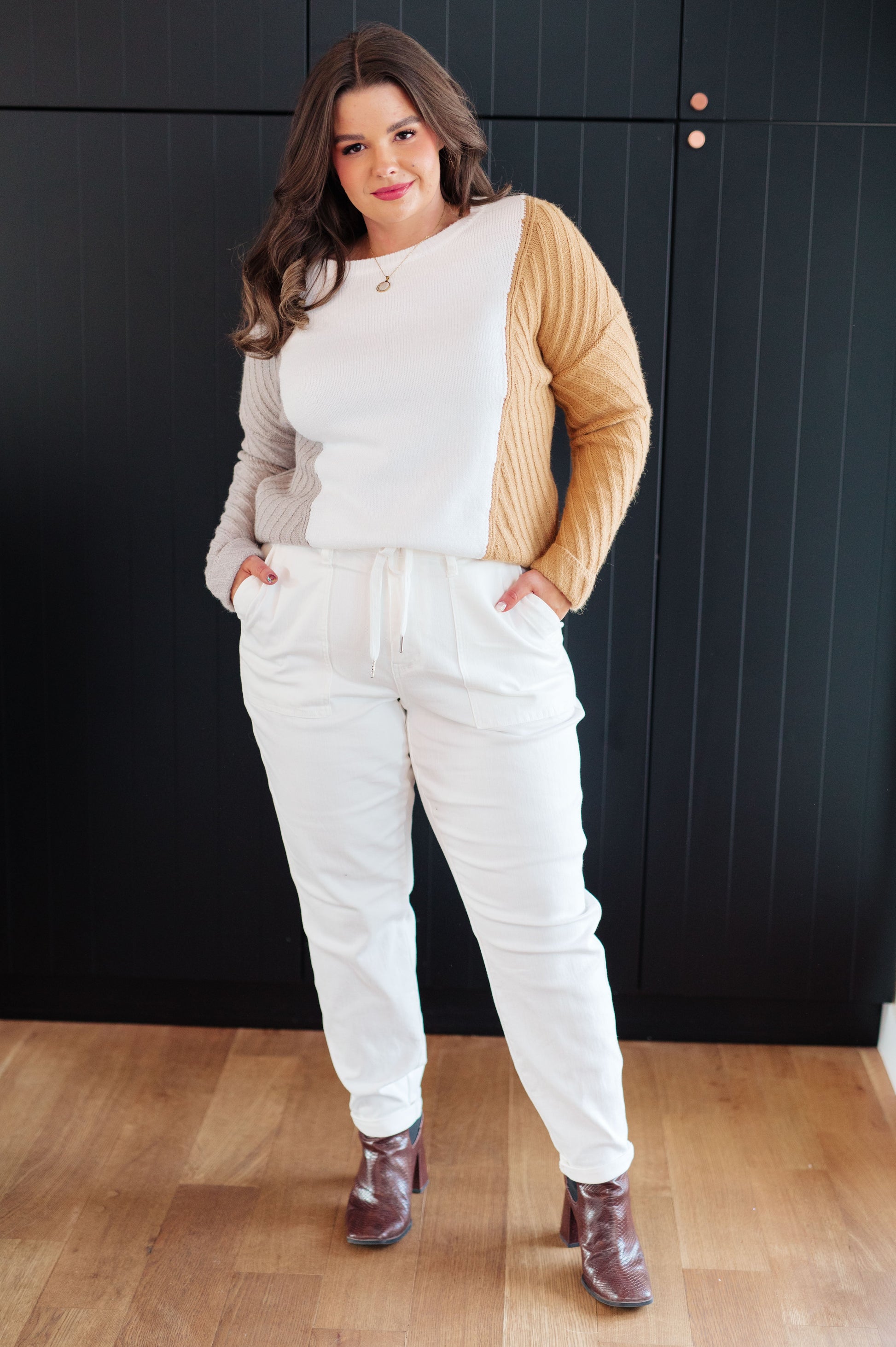 Plus size model wearing Makenna Color Block Sweater with white joggers.