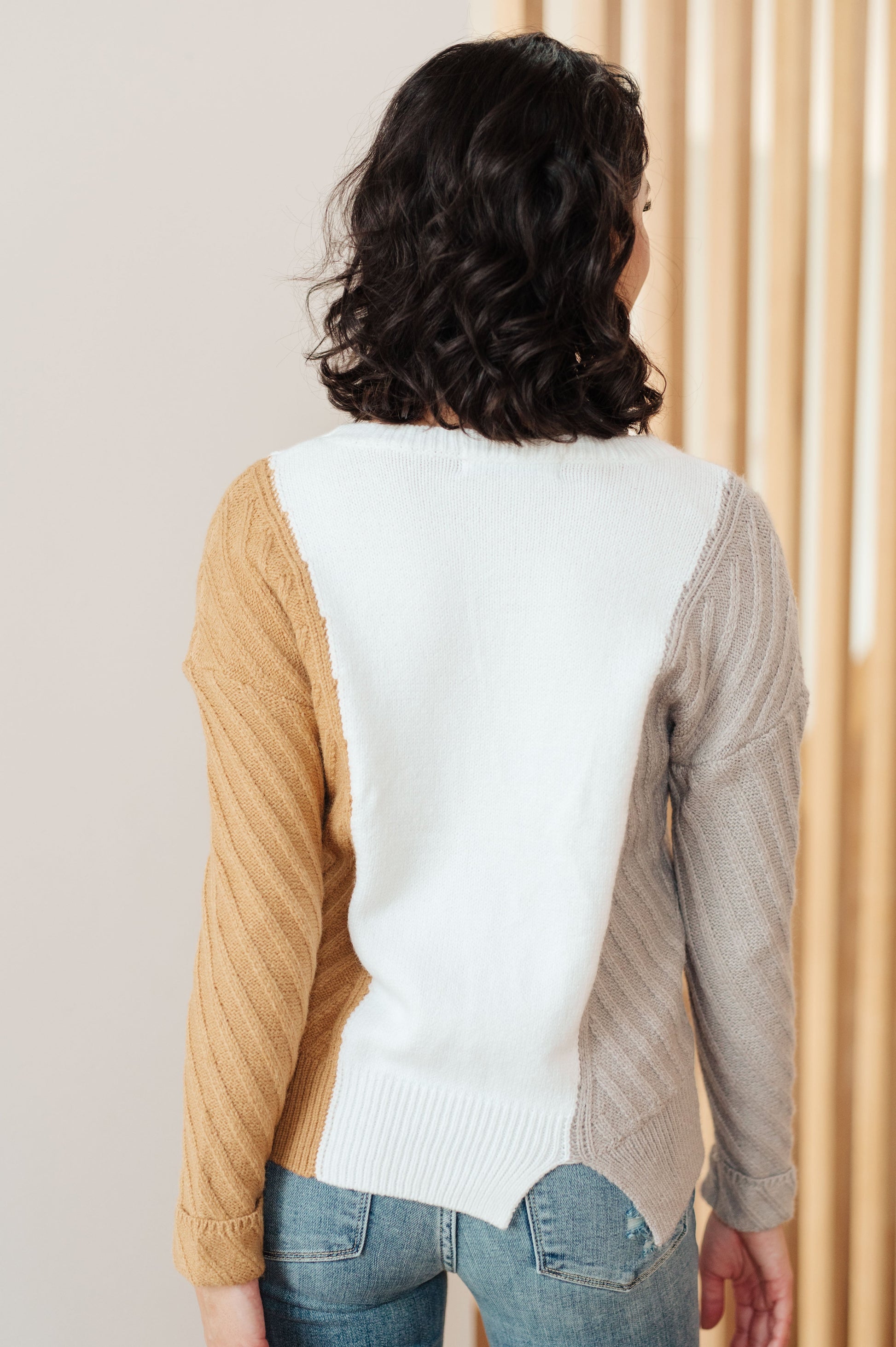 Back of Makenna Color Block Sweater showing white panel and ribbed knit sleeves.