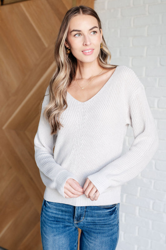 Model wearing Toula Ribbed Knit V Neck Sweater in cream with slim fit silhouette.
