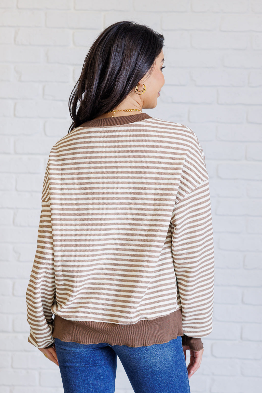 Women's brown striped drop shoulder top with long sleeves, banded ribbed neckline, cuffs, and hemline, made of midweight knit fabric.