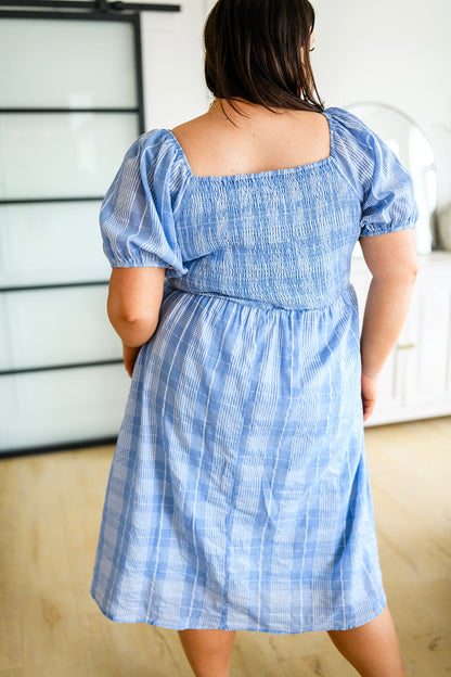 Plus size back view of Payson Puff Sleeve Dress showing smocked stretch fit, puff sleeves, and blue plaid midi skirt.