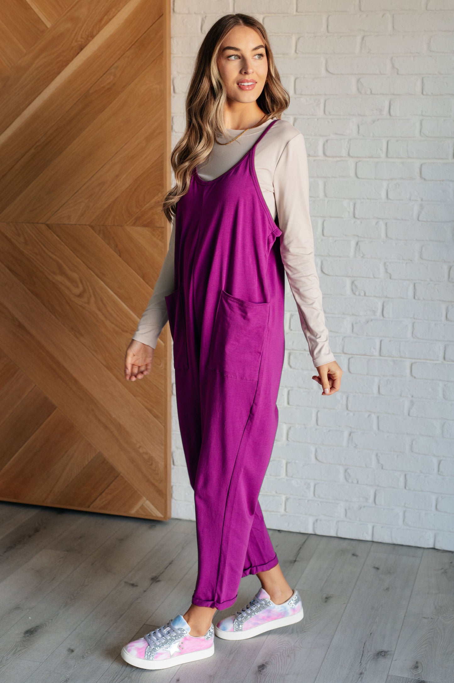 Light Plum spaghetti strap jumpsuit with a scooped neckline, patch pockets, and tacked cuffs at the hem.