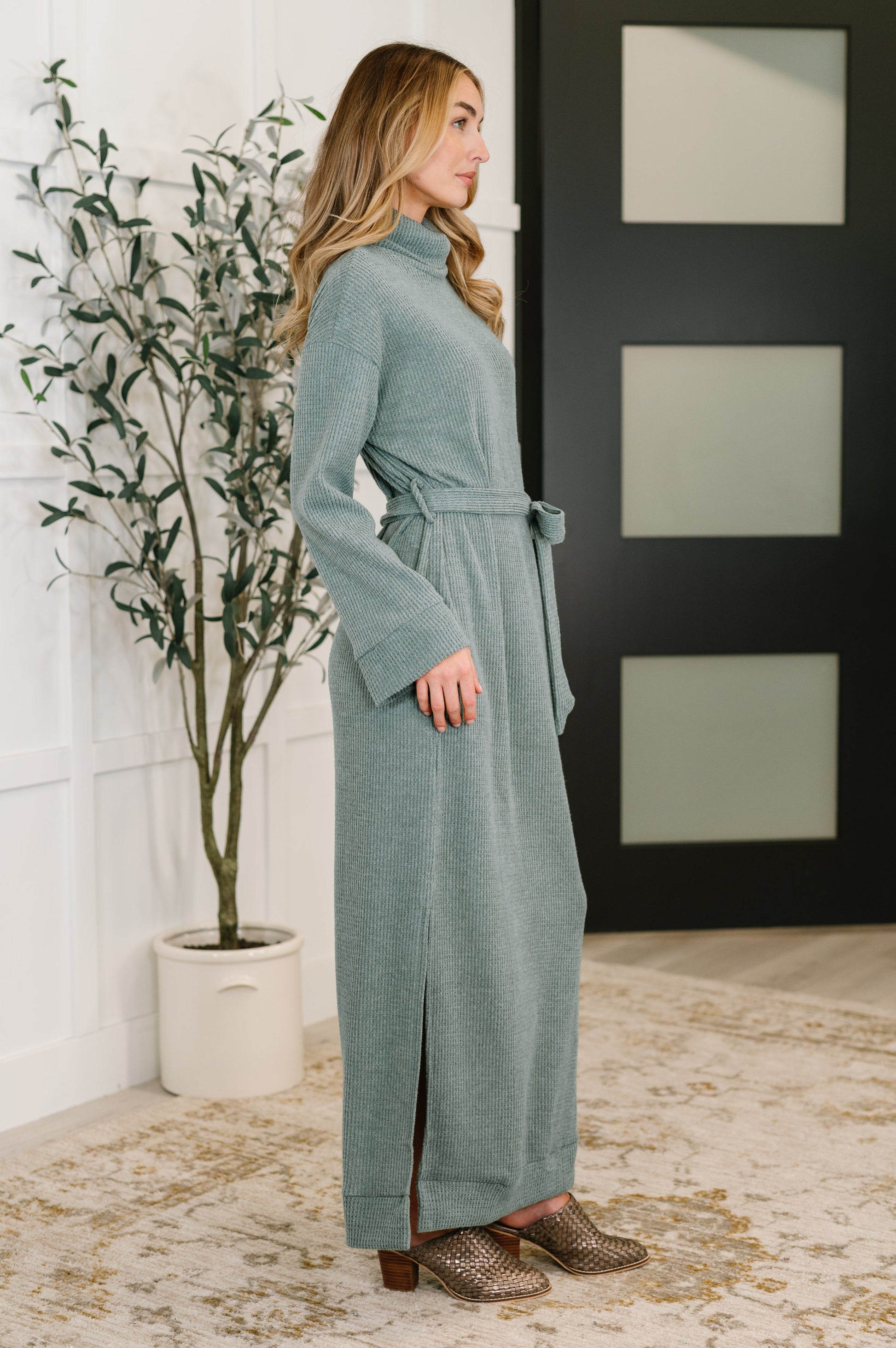 Side view of Travita Plush Knit Dress in Soft Teal with high stretch fit and side slits.