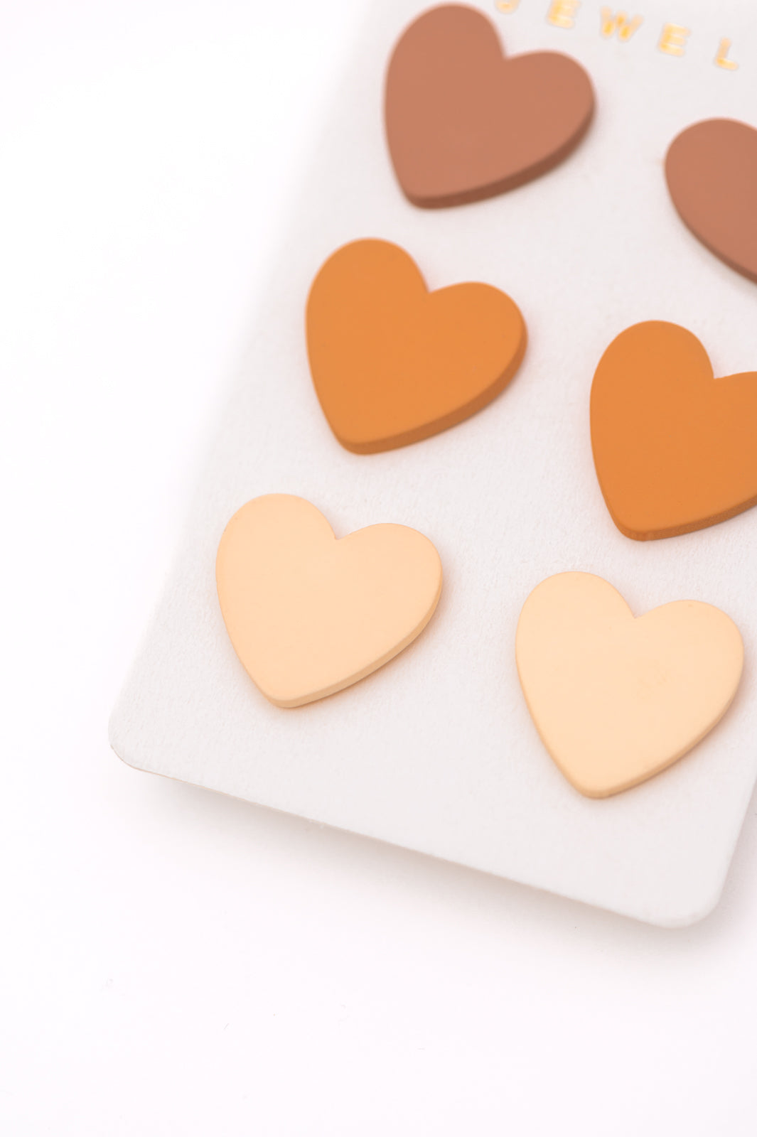 3 Pack of heart stud earrings in neutral colors.