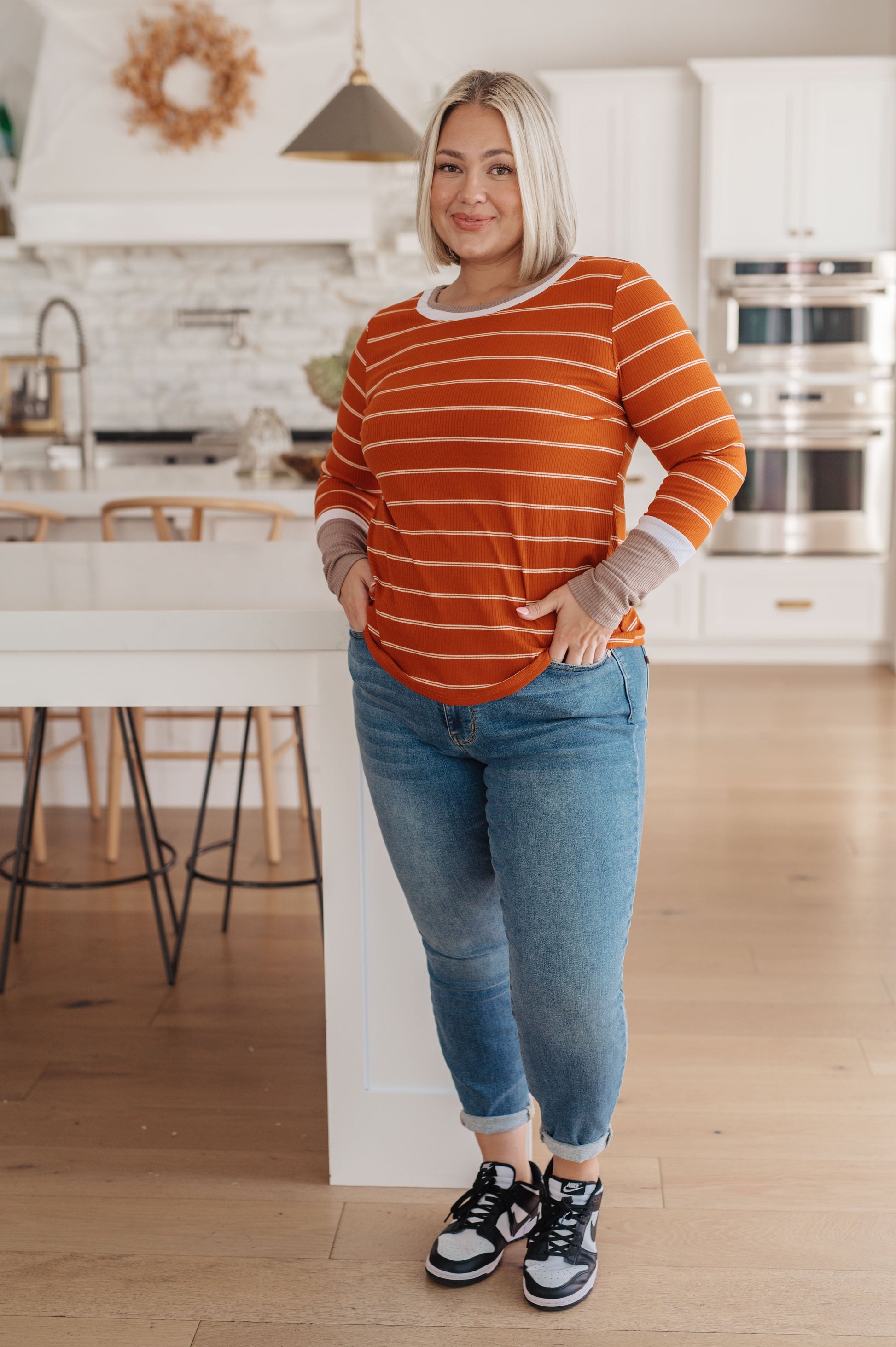 Orange and white striped ribbed jersey knit long sleeve tee with taupe color-blocked cuffs and a slim fit.