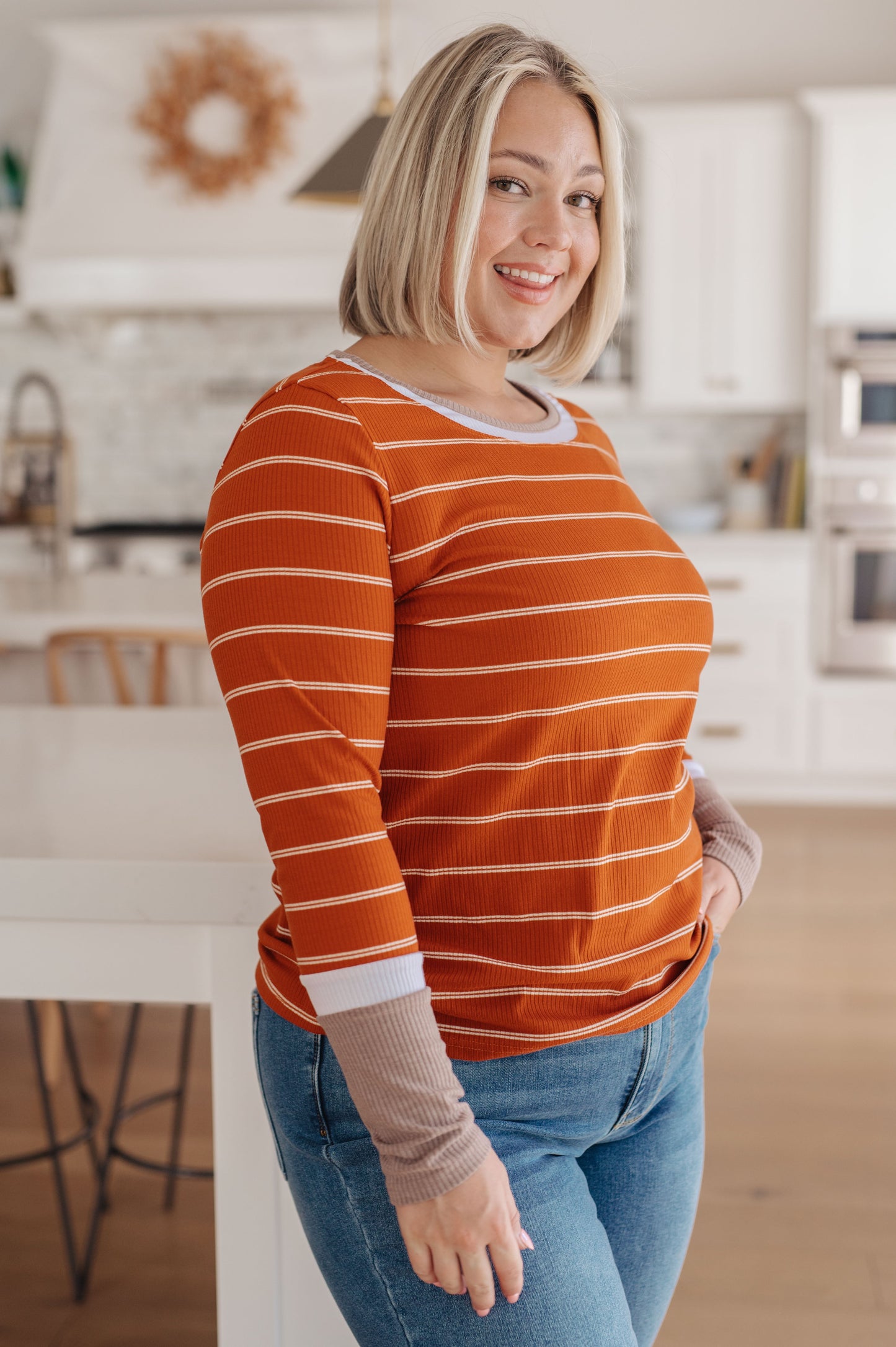 Orange and white striped ribbed jersey knit long sleeve tee with taupe color-blocked cuffs and a slim fit.