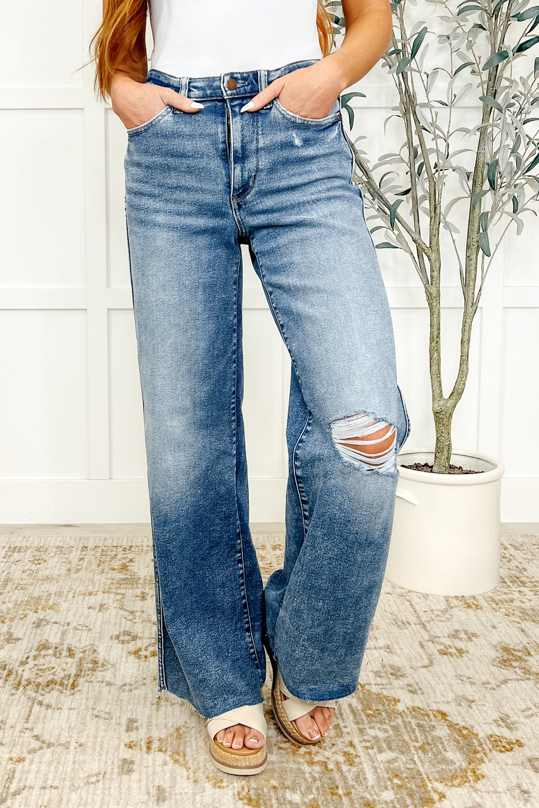 Front view of Judy Blue Tucker Wide Leg Jeans in medium vintage wash with distressed knees and raw hem.