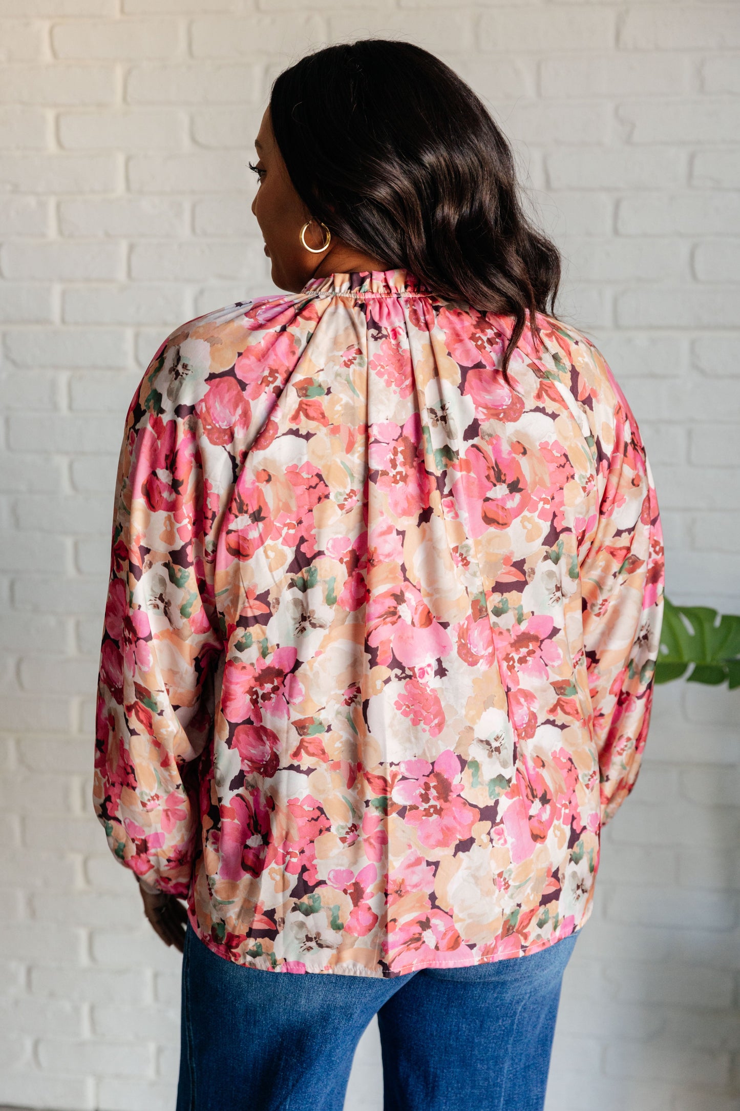 Women's pink floral blouse with poet sleeves, banded cuffs, ruffle details, and a high-low hem.