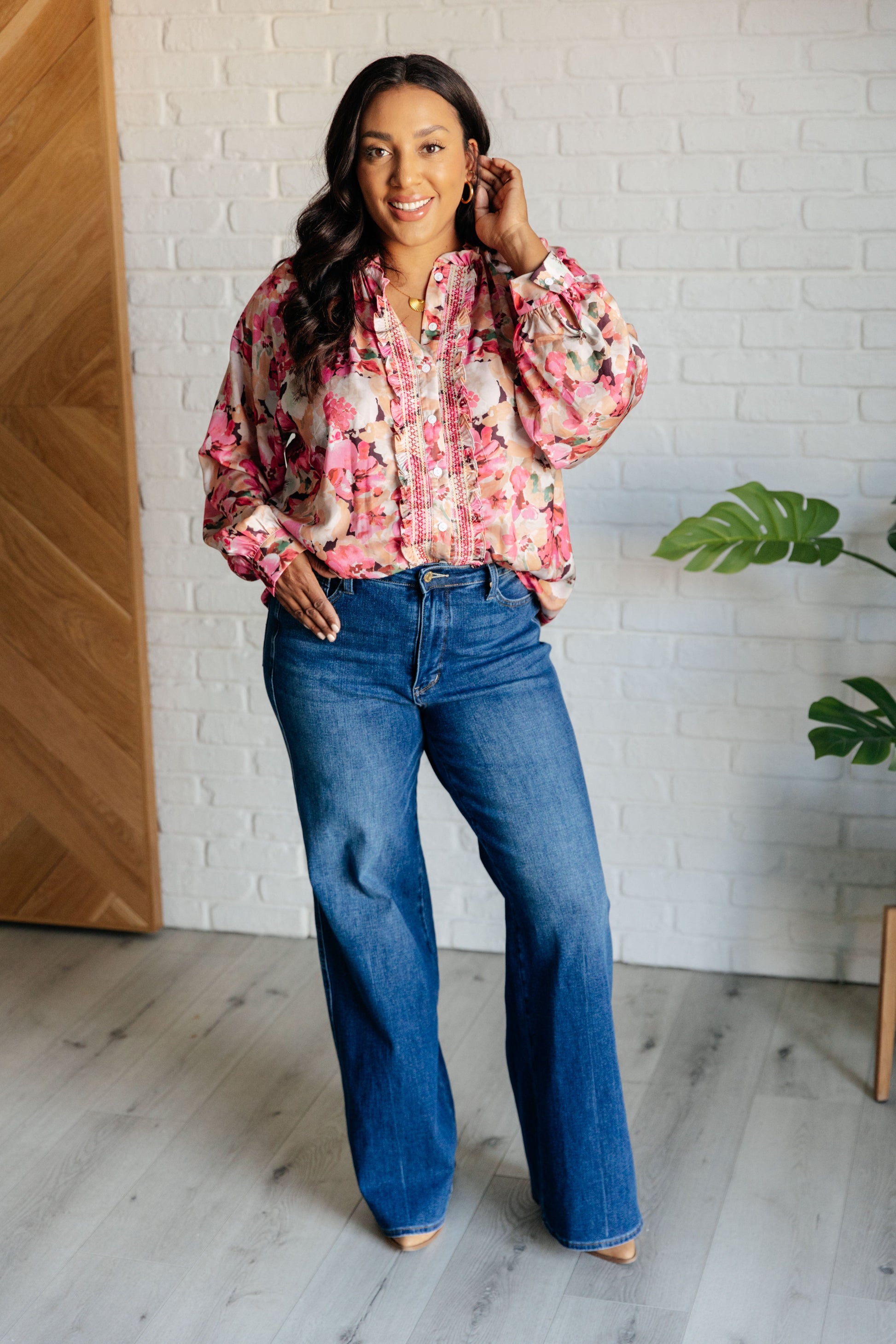 Women's pink floral blouse with poet sleeves, banded cuffs, ruffle details, and a high-low hem.