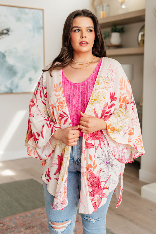 Plus size model wearing pink floral Mei Bell Sleeve Kimono open over a tank top and jeans