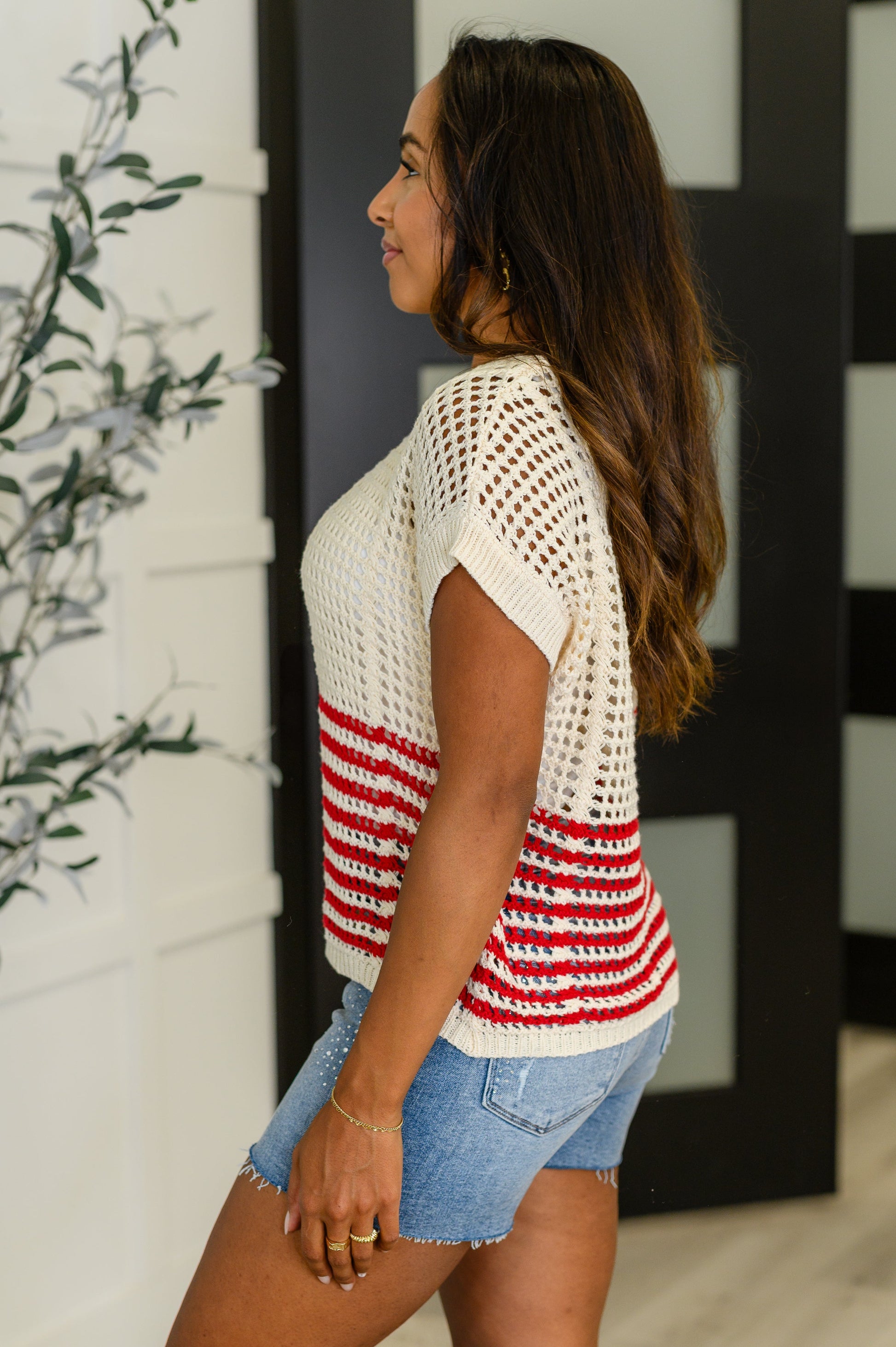 Side view of Cora Net Tee in red stripes, showing dolman sleeve and relaxed stretch fit.