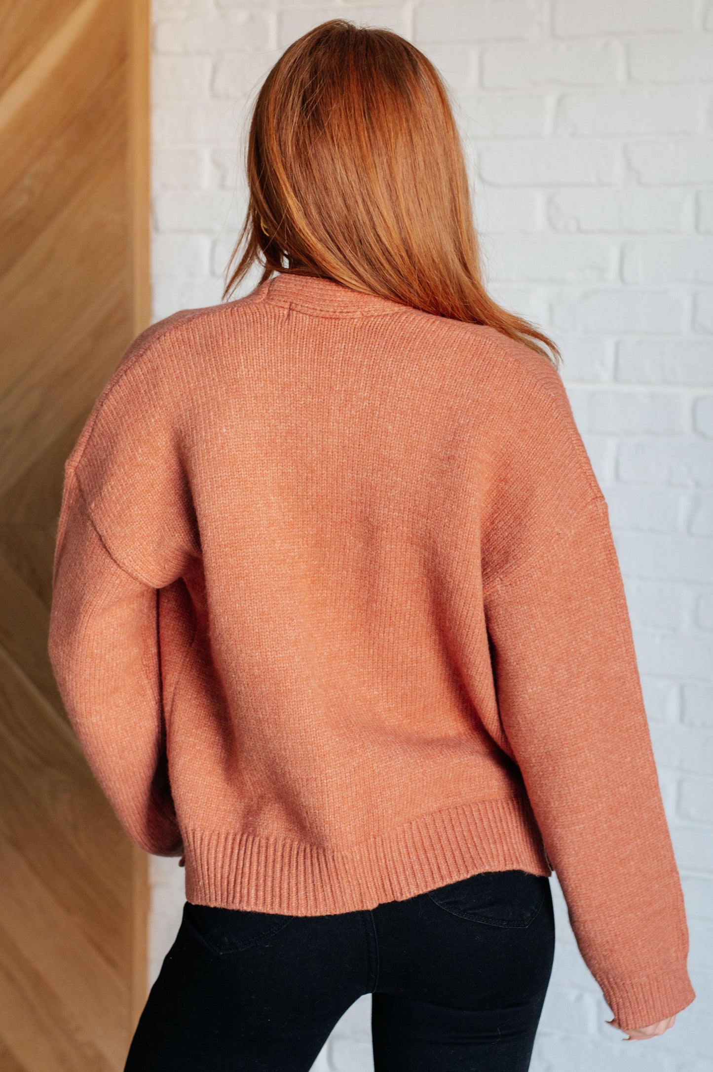 A women's cardigan made from brushed midweight sweater knit in a warm cider color. Features an open front design, long sleeves with drop shoulders, and a banded ribbed hemline.