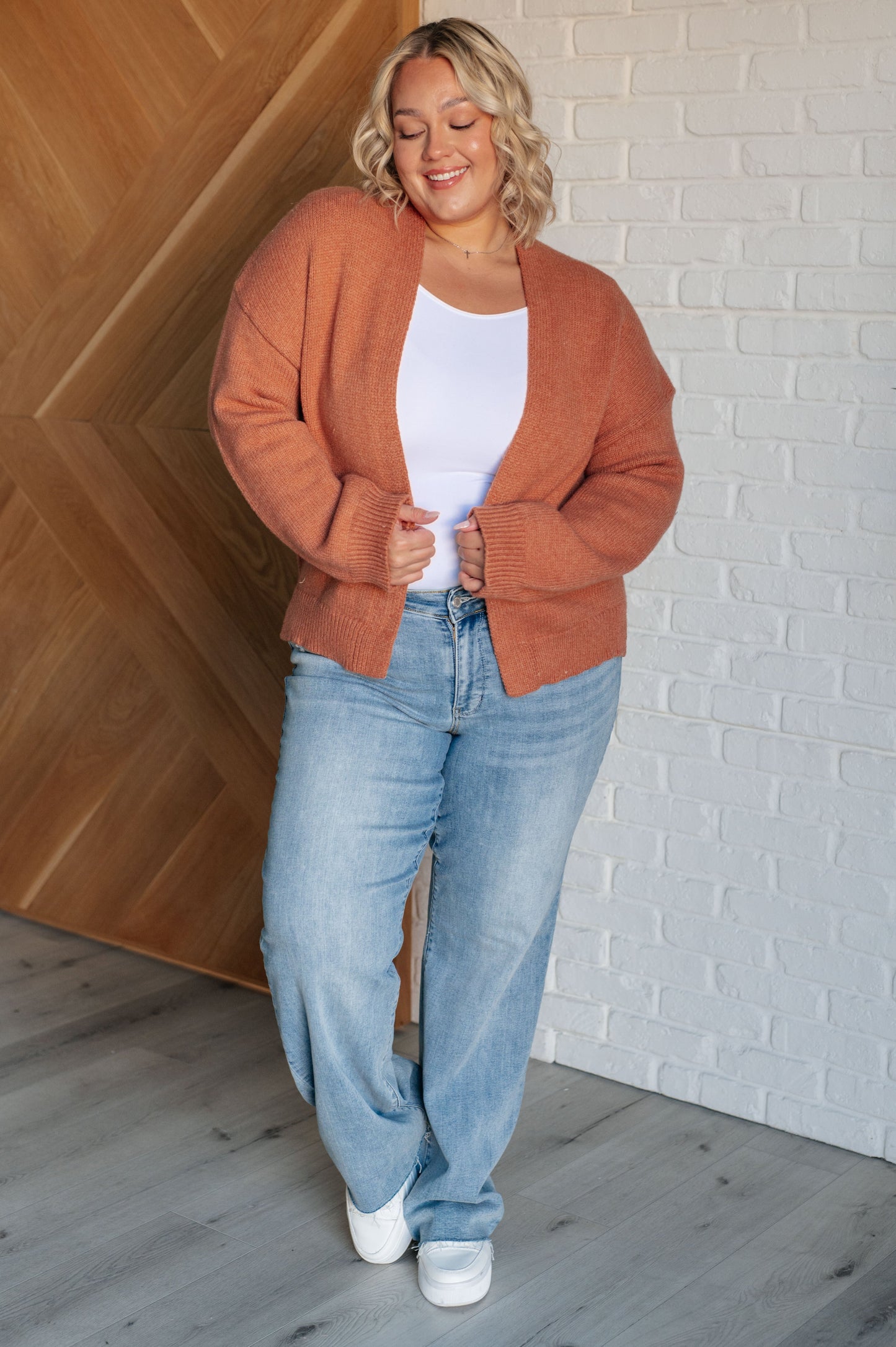 A women's cardigan made from brushed midweight sweater knit in a warm cider color. Features an open front design, long sleeves with drop shoulders, and a banded ribbed hemline.