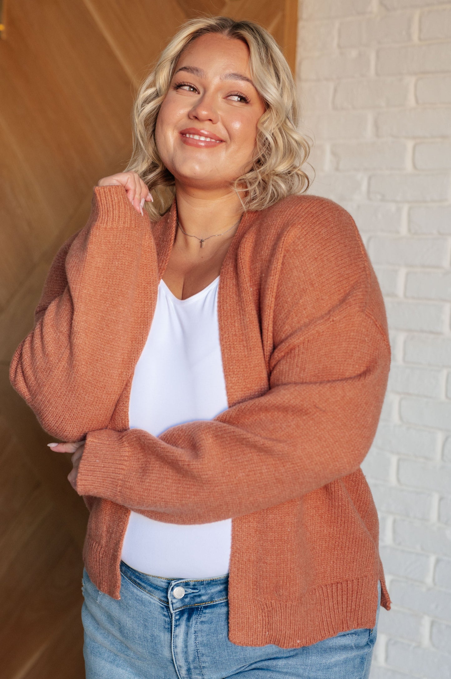 A women's cardigan made from brushed midweight sweater knit in a warm cider color. Features an open front design, long sleeves with drop shoulders, and a banded ribbed hemline.