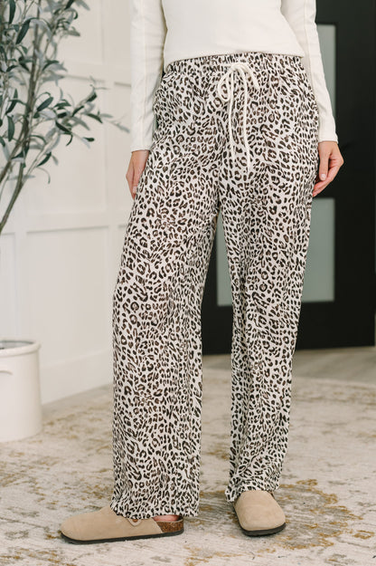 Woman wearing Wania Leopard Drawstring Pants, cream base with wide leg silhouette and high-waisted fit.
